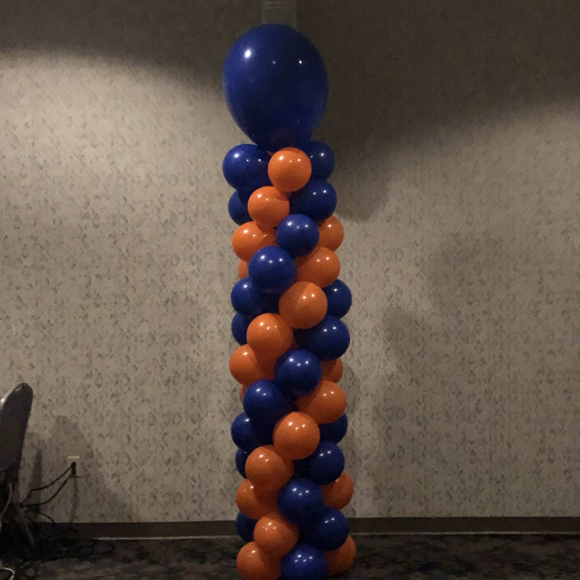 Tall column of blue and orange balloons in a room
