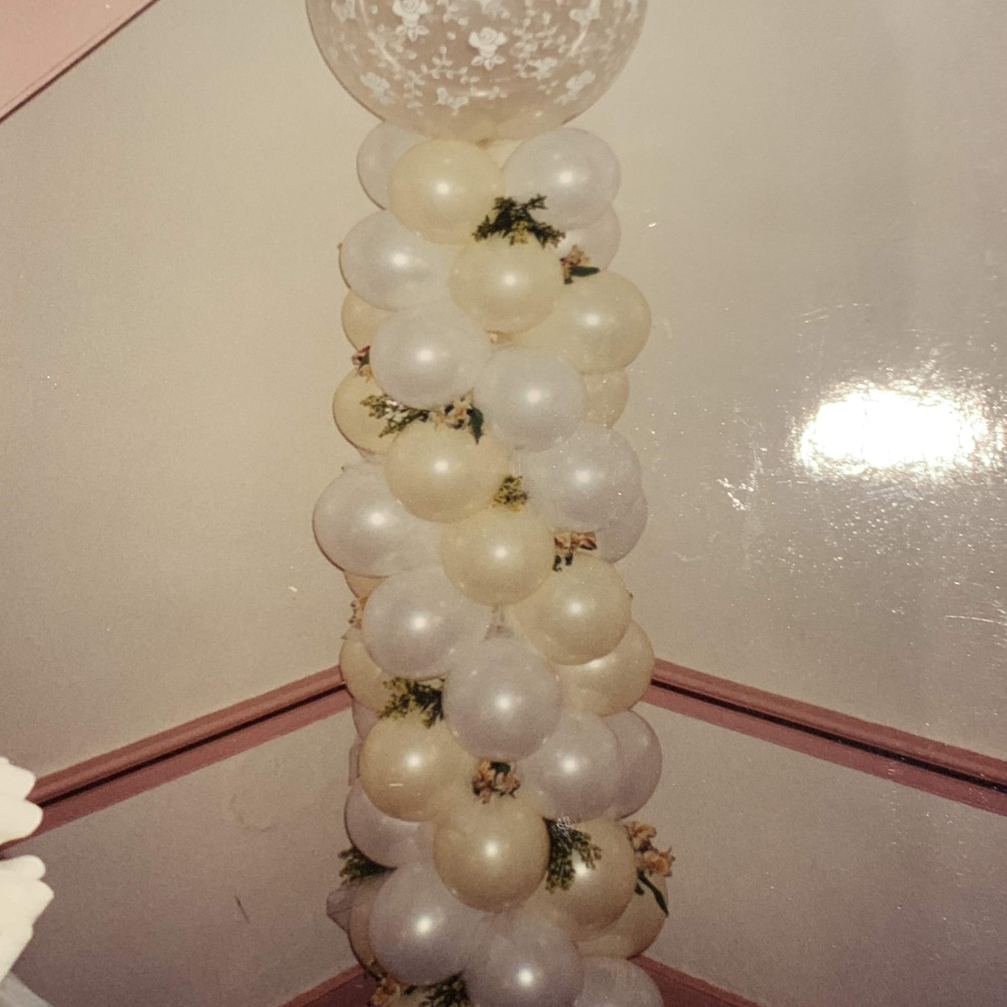 Tall column of cream and clear balloons with floral prints