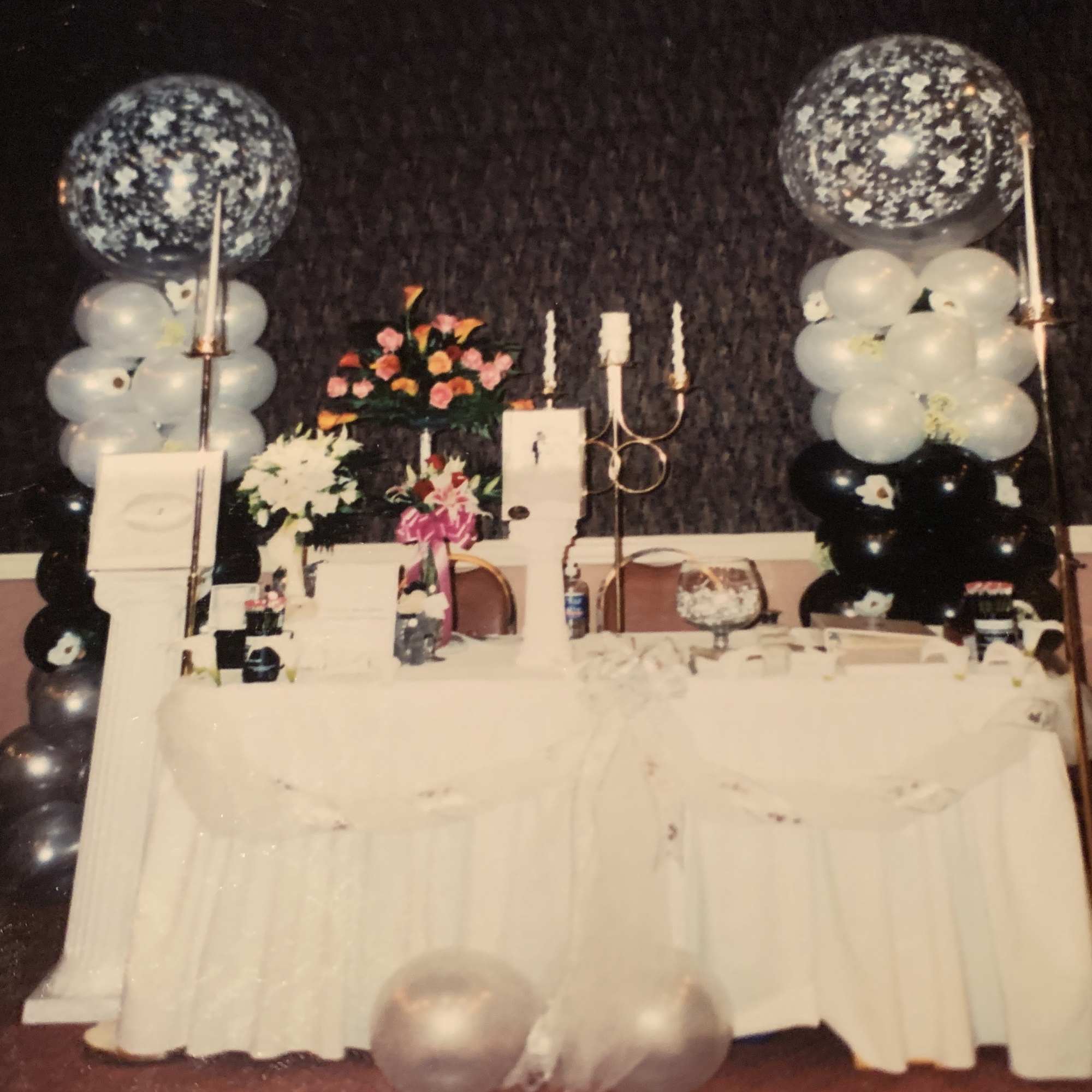 Decorated banquet table with floral arrangements and balloon columns