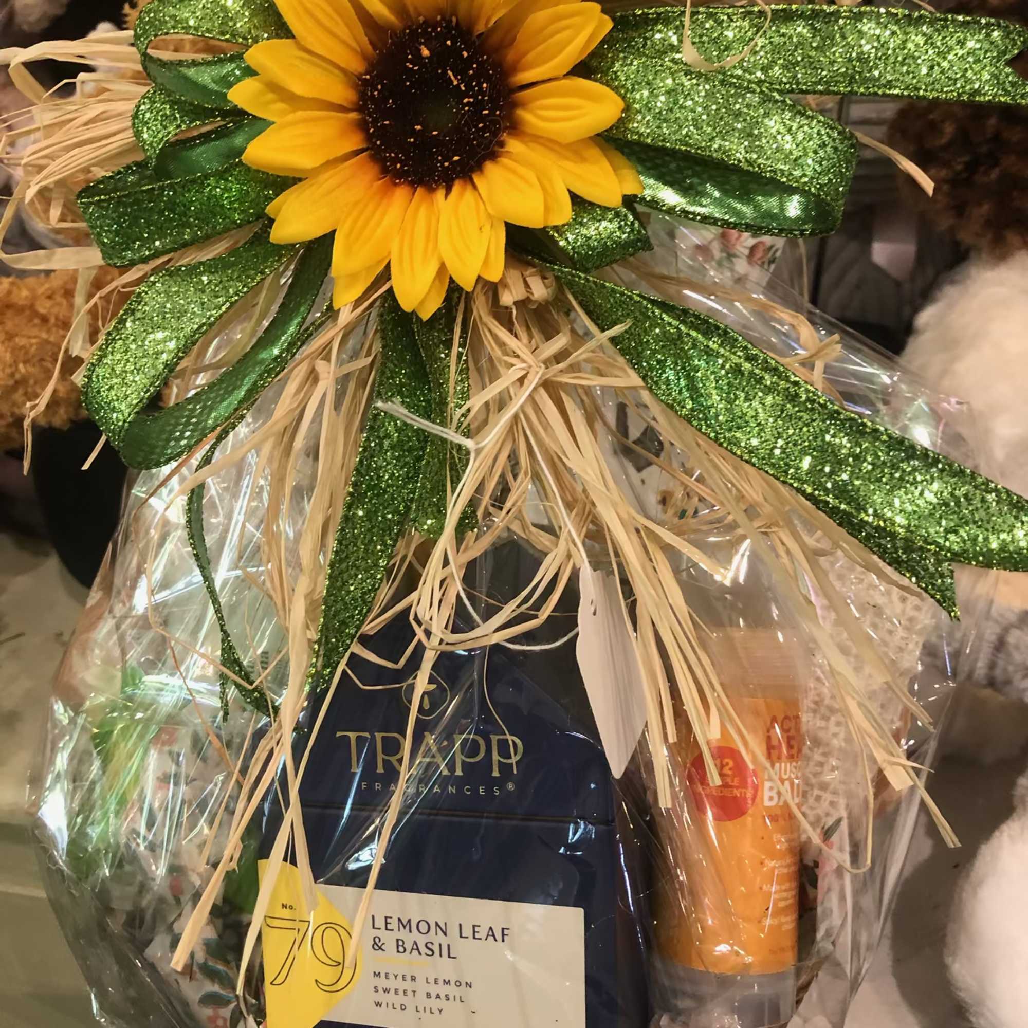 Gift basket with a sunflower topper and candles wrapped in clear cellophane