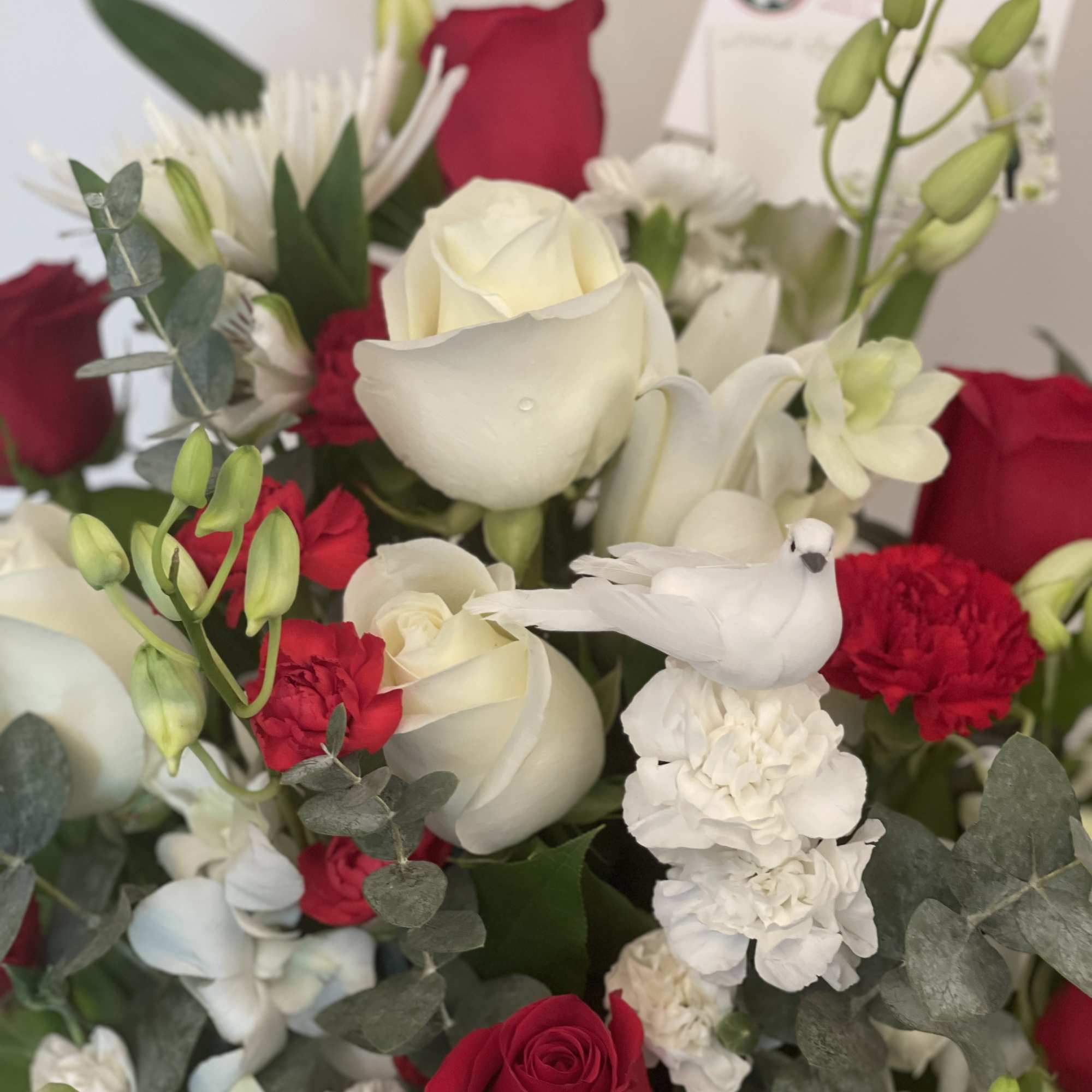Bouquet of red and white roses with white orchids and carnations