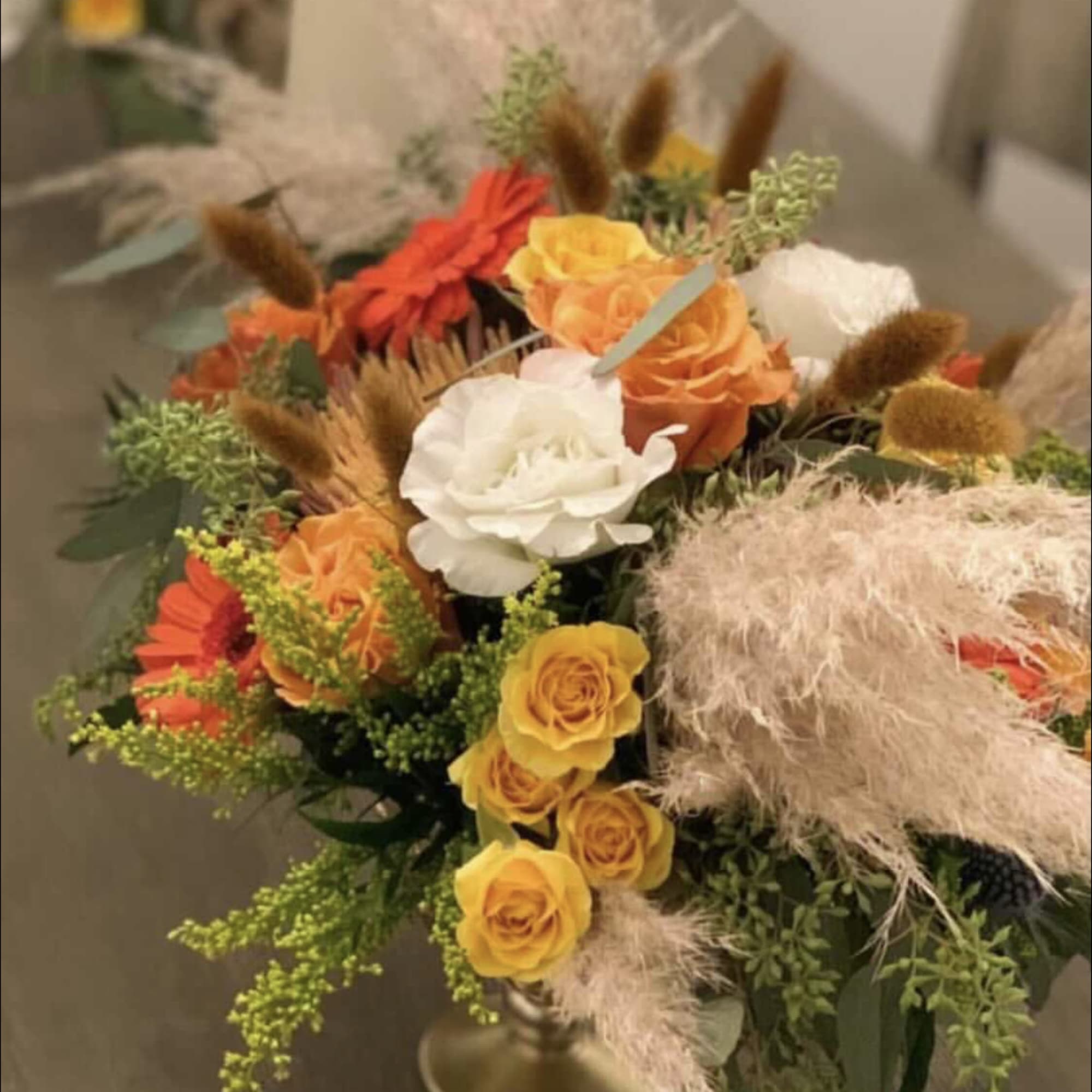 Mixed bouquet of orange, yellow, white, and red flowers in a vase