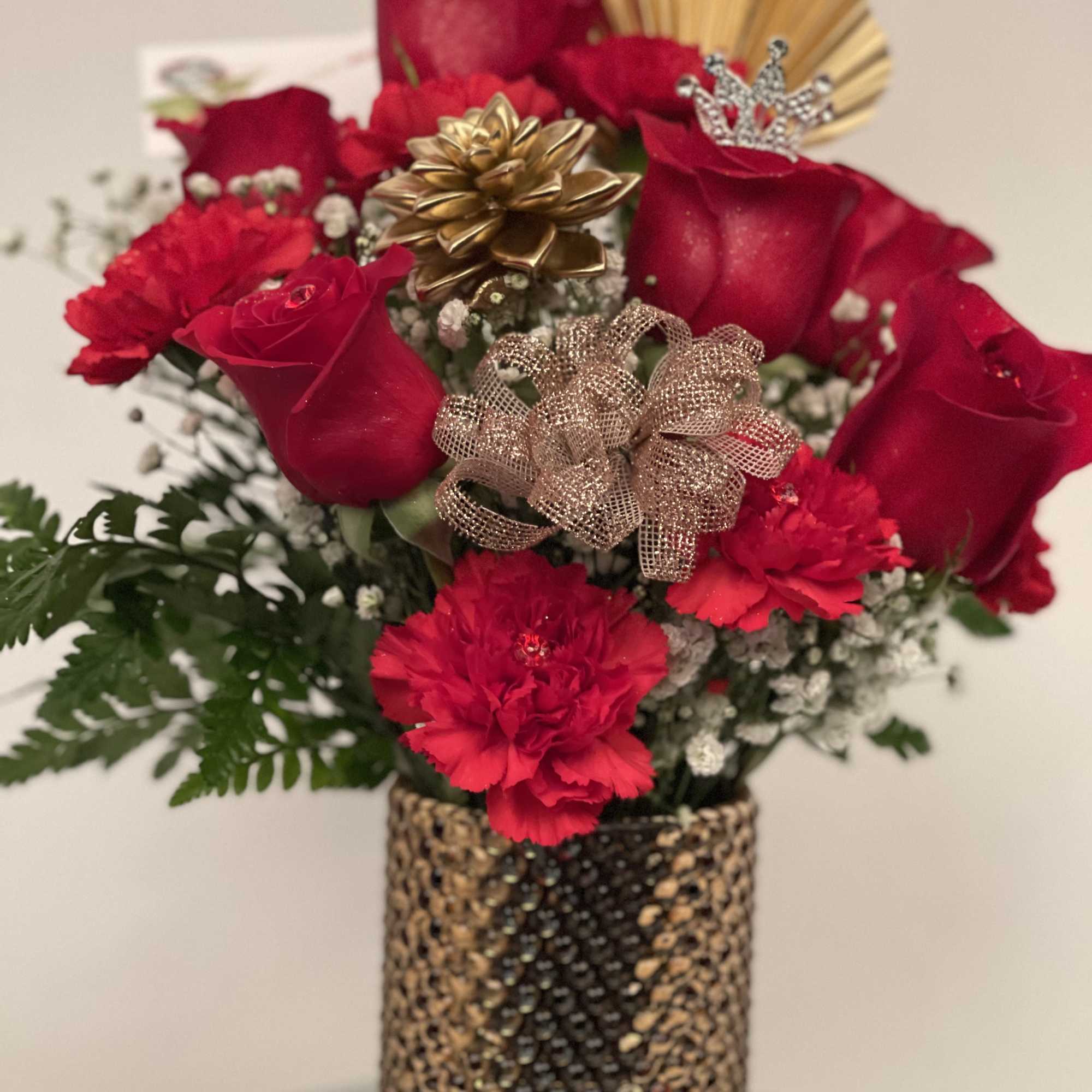 Red roses and carnations in a gold vase with decorative bows