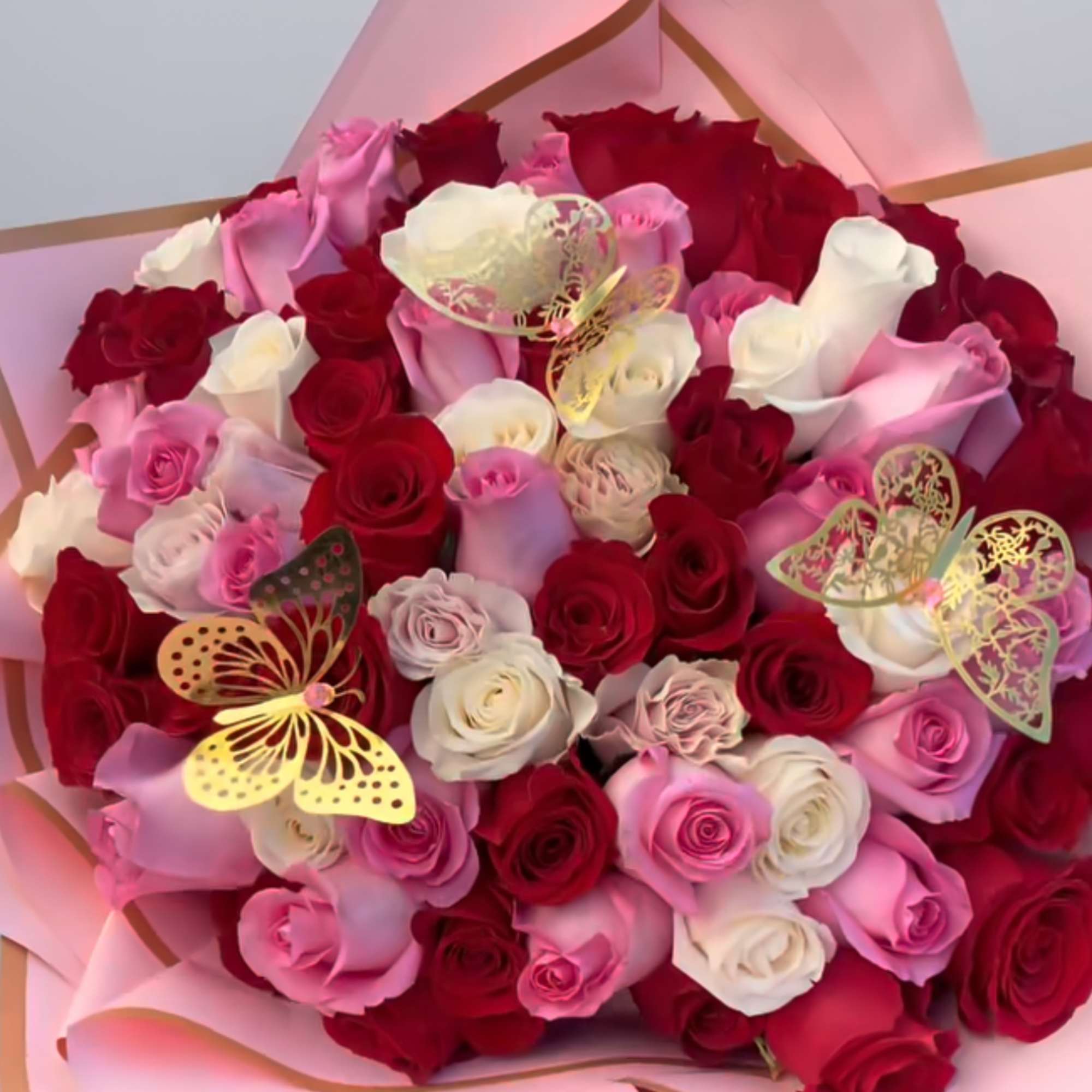 Bouquet of red, pink, and white roses wrapped in pink paper, photo 3 of 3