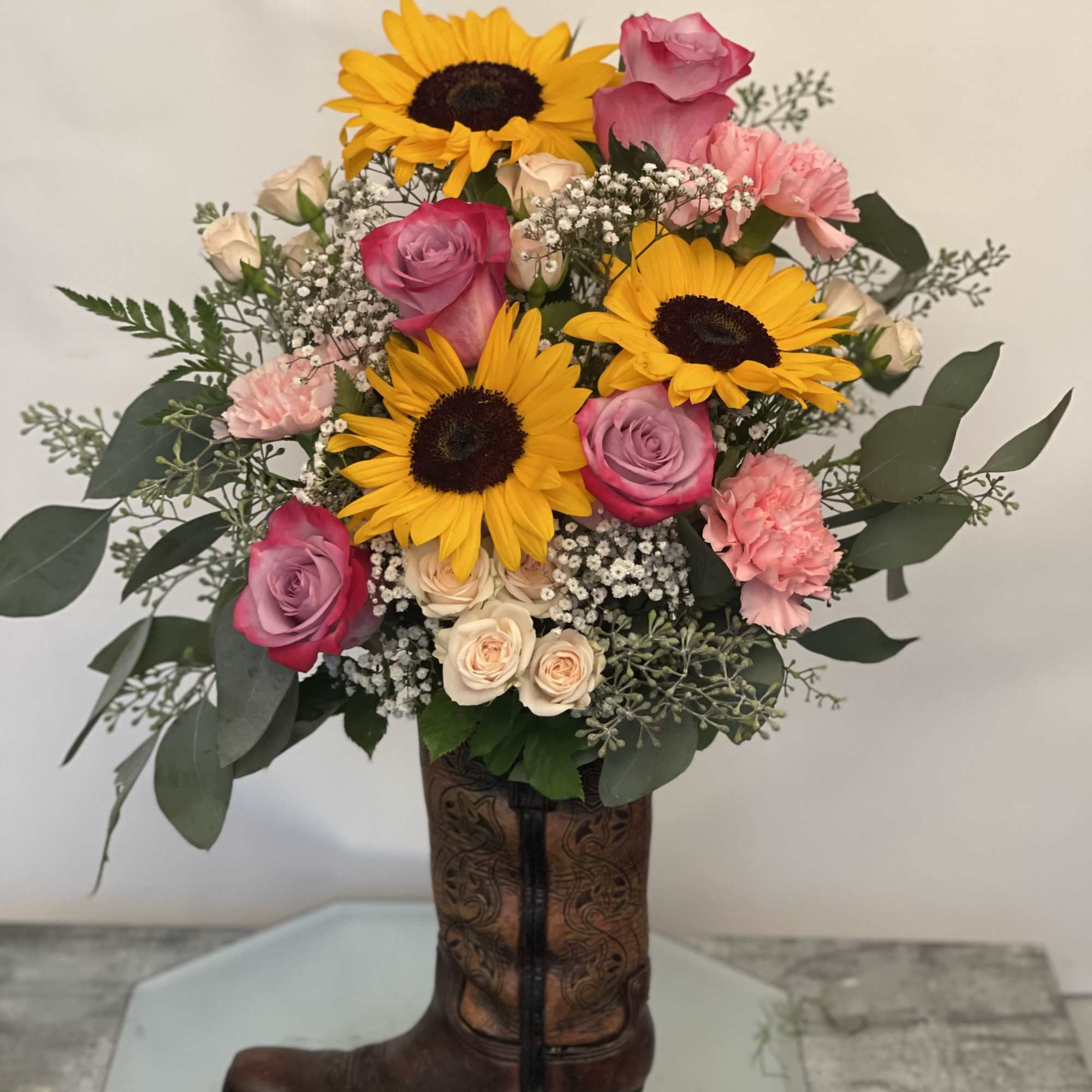 Bouquet of sunflowers, pink roses, and carnations in a cowboy boot vase, photo 2 of 2