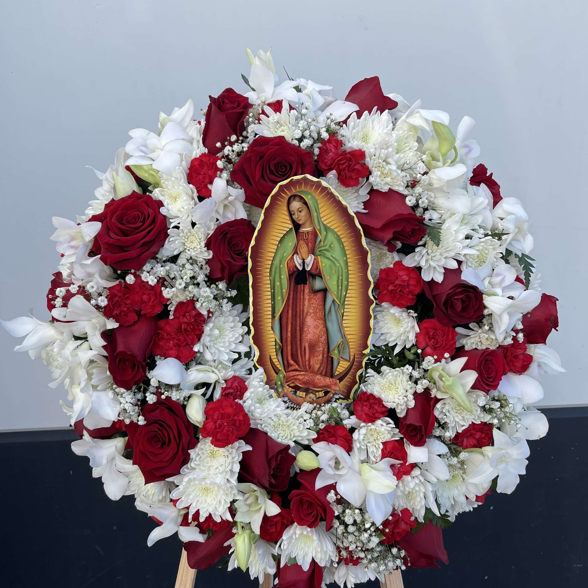 Red and white floral wreath with a religious image in the center