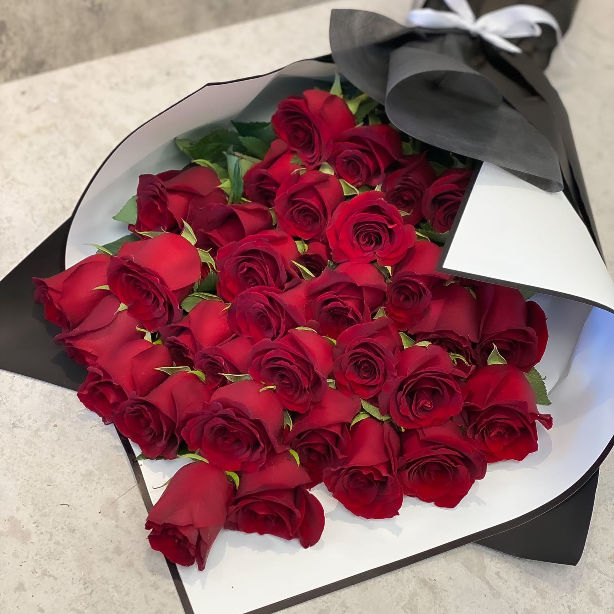 Bouquet of red roses wrapped in black and white paper