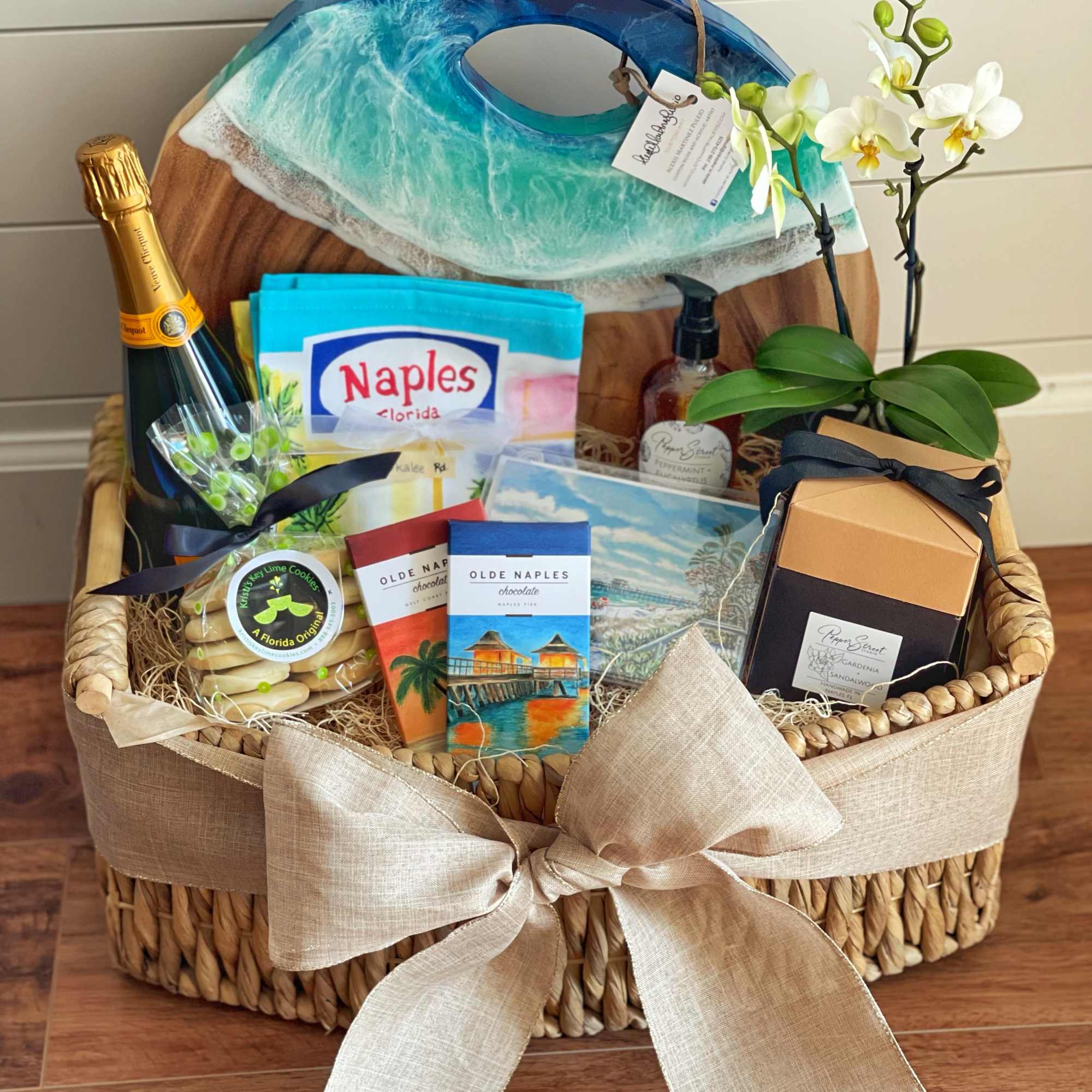 Gift basket with orchids, chocolates, cookies, and a champagne bottle