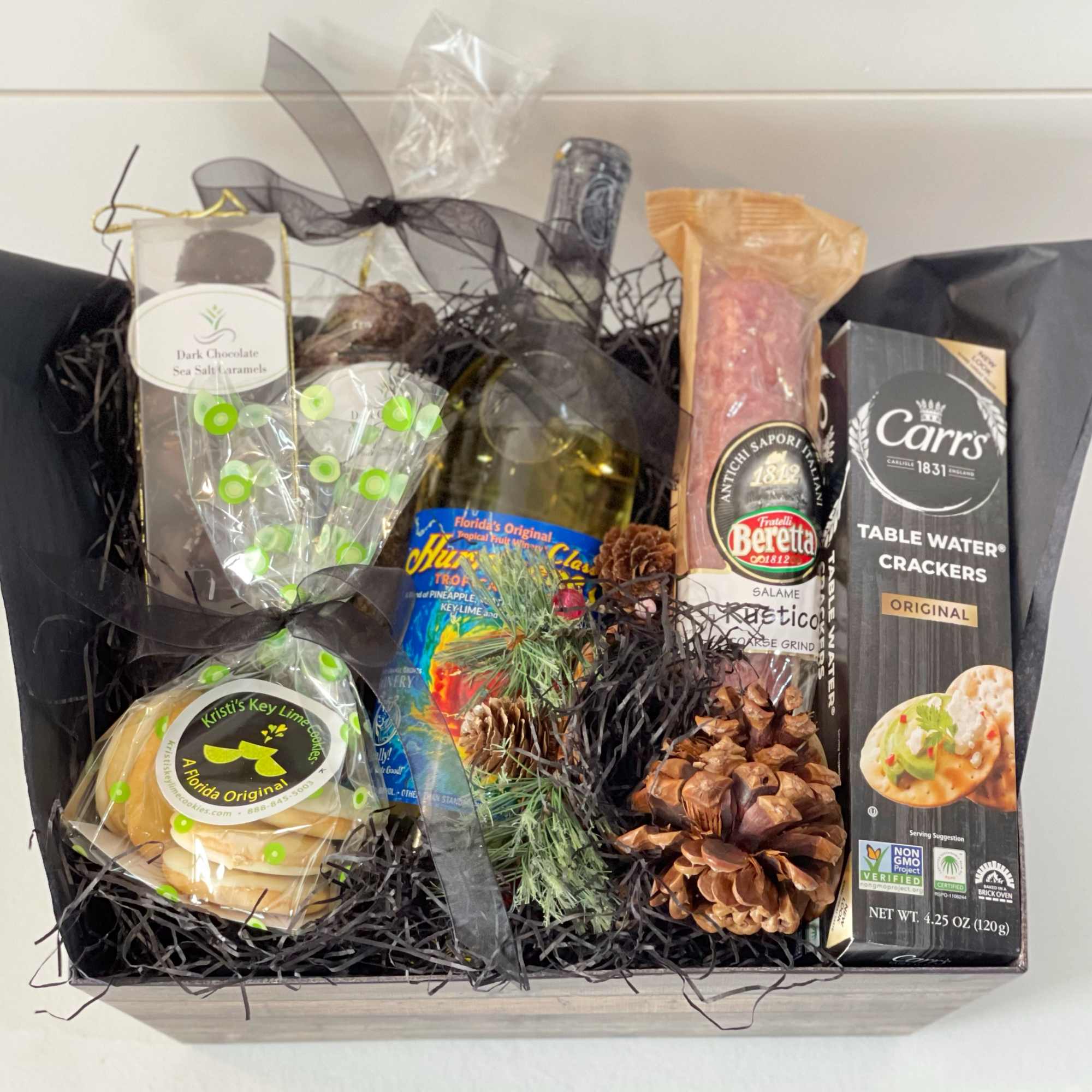 Gift basket with chocolates, cookies, salami, crackers, and a bottle of wine