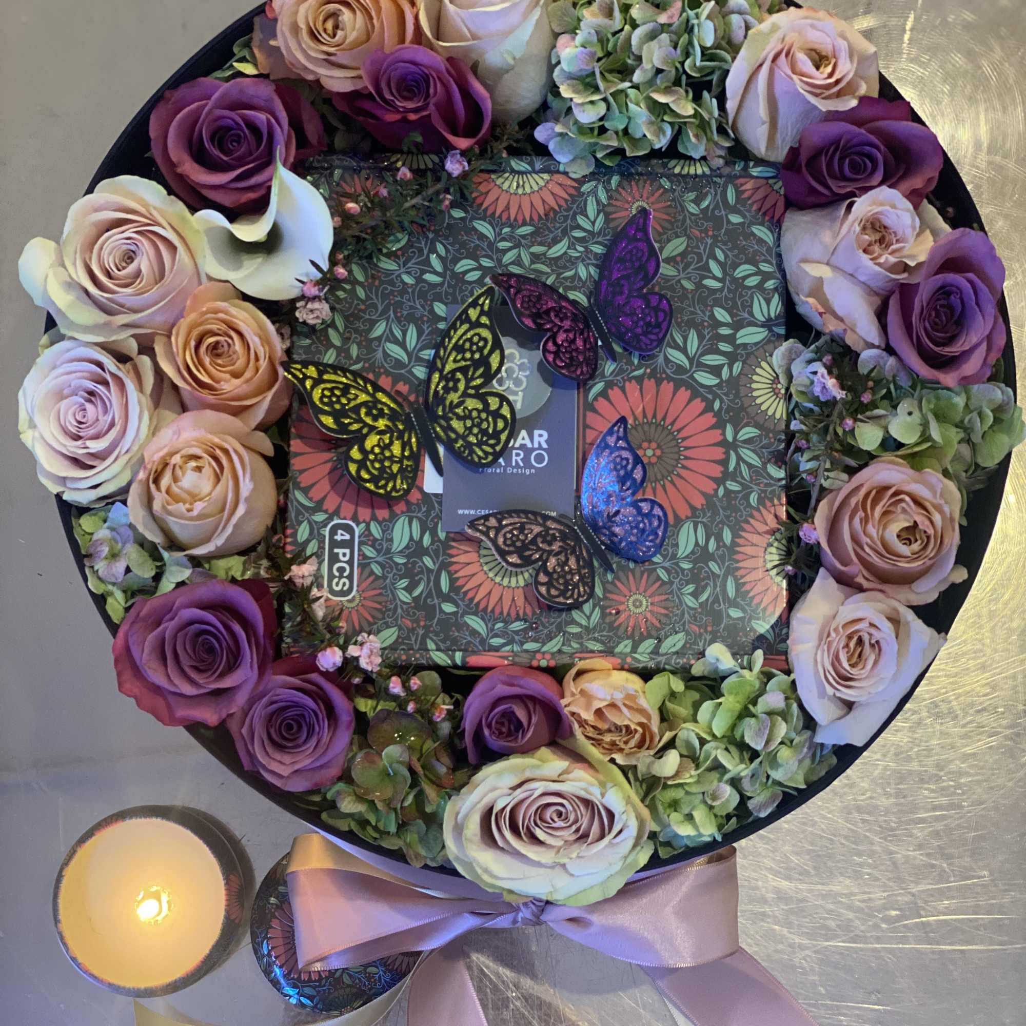 Round box arranged with 4 scented candles and fresh flowers