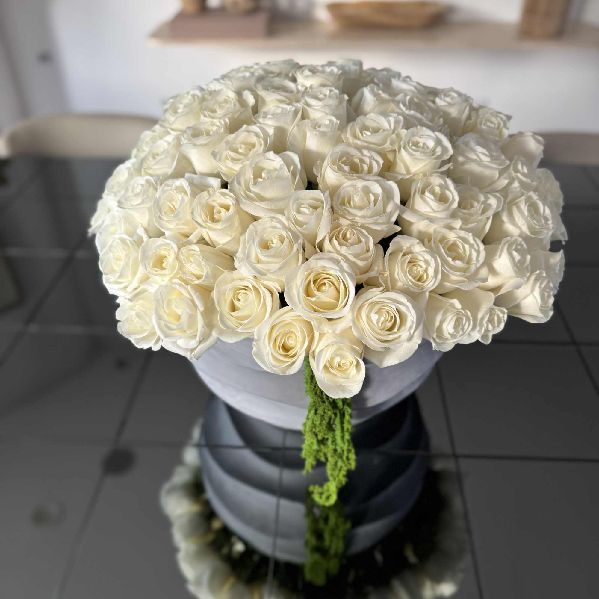 Pure white roses in a concrete vase, filling the space with structure