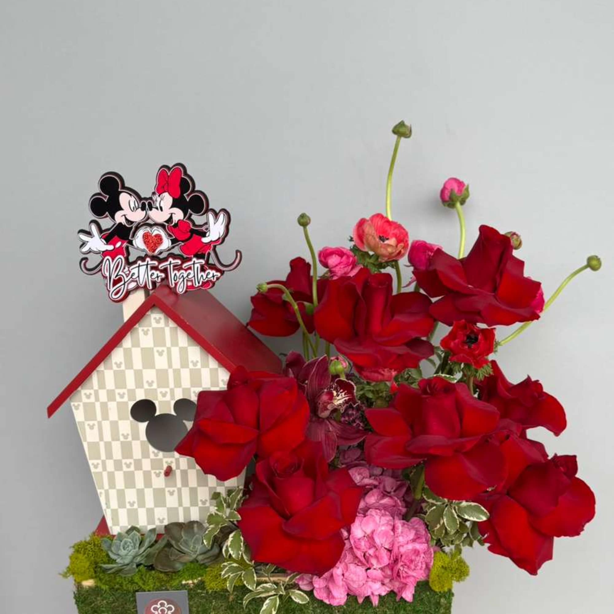 Romantic red roses paired with delicate ranunculus and bold anemones, beautifully styled