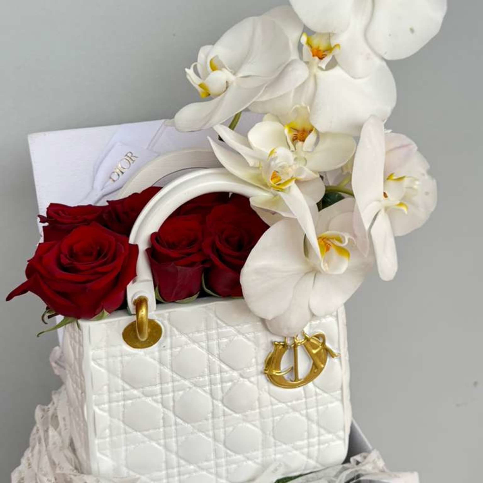 Elegant red roses and Sophisticated Orchids artfully arranged in a stunning white