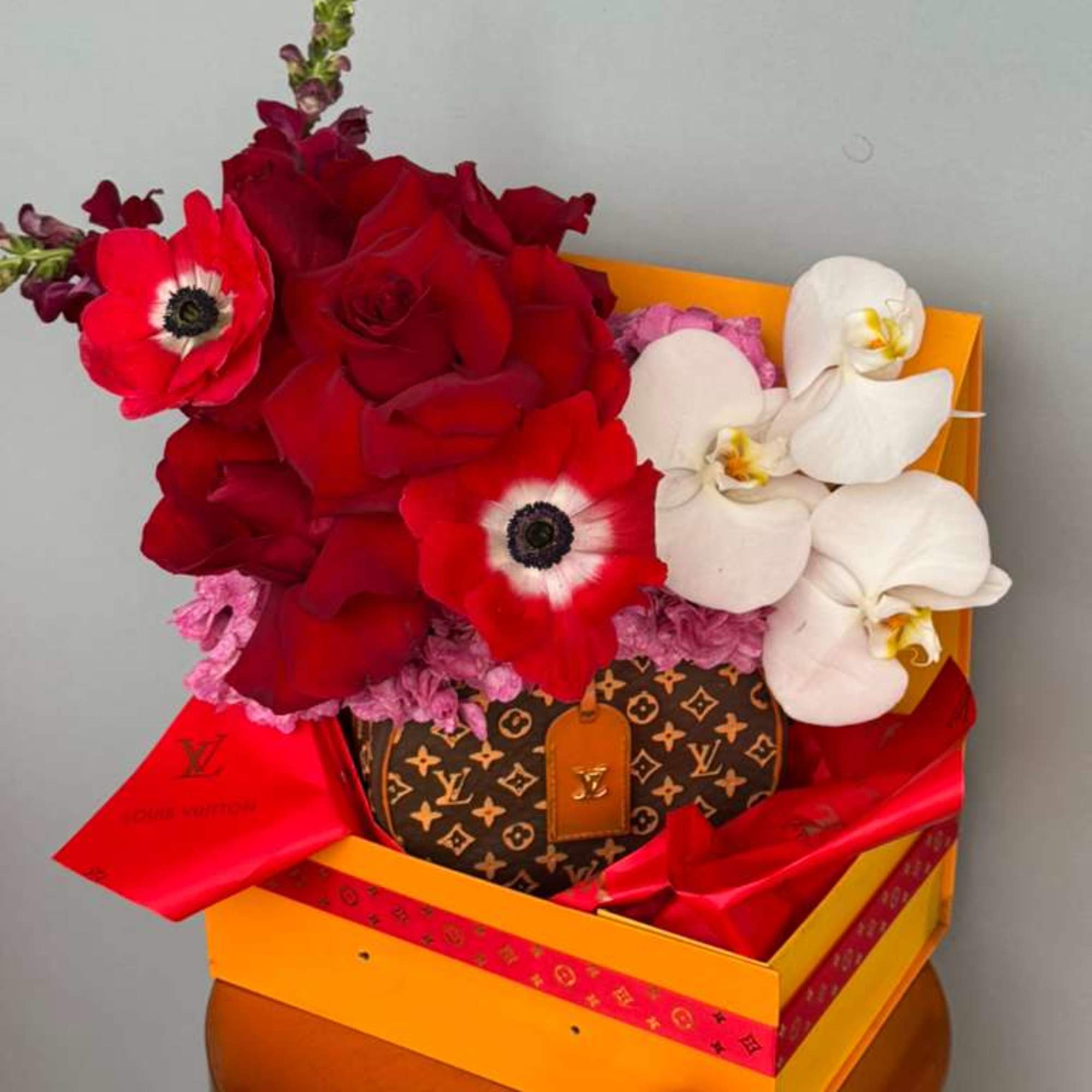 Elegant red roses paired with graceful blooms beautifully arranged in a designer-inspired