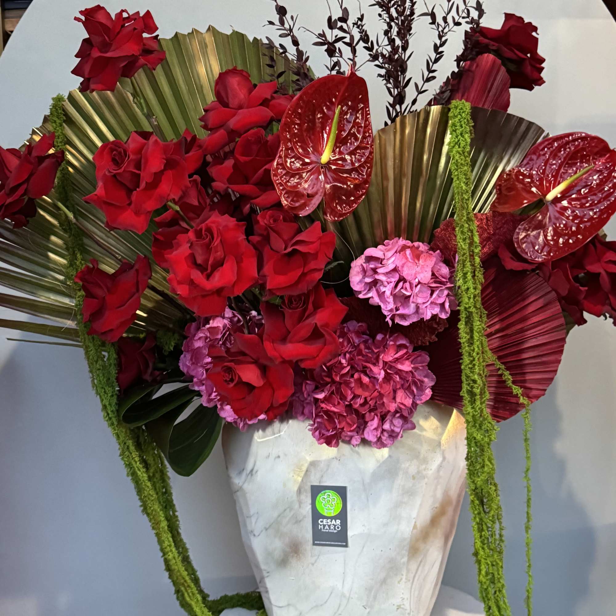 Large white base with vibrant reds and pinks, accented by graceful palm, photo 2 of 2