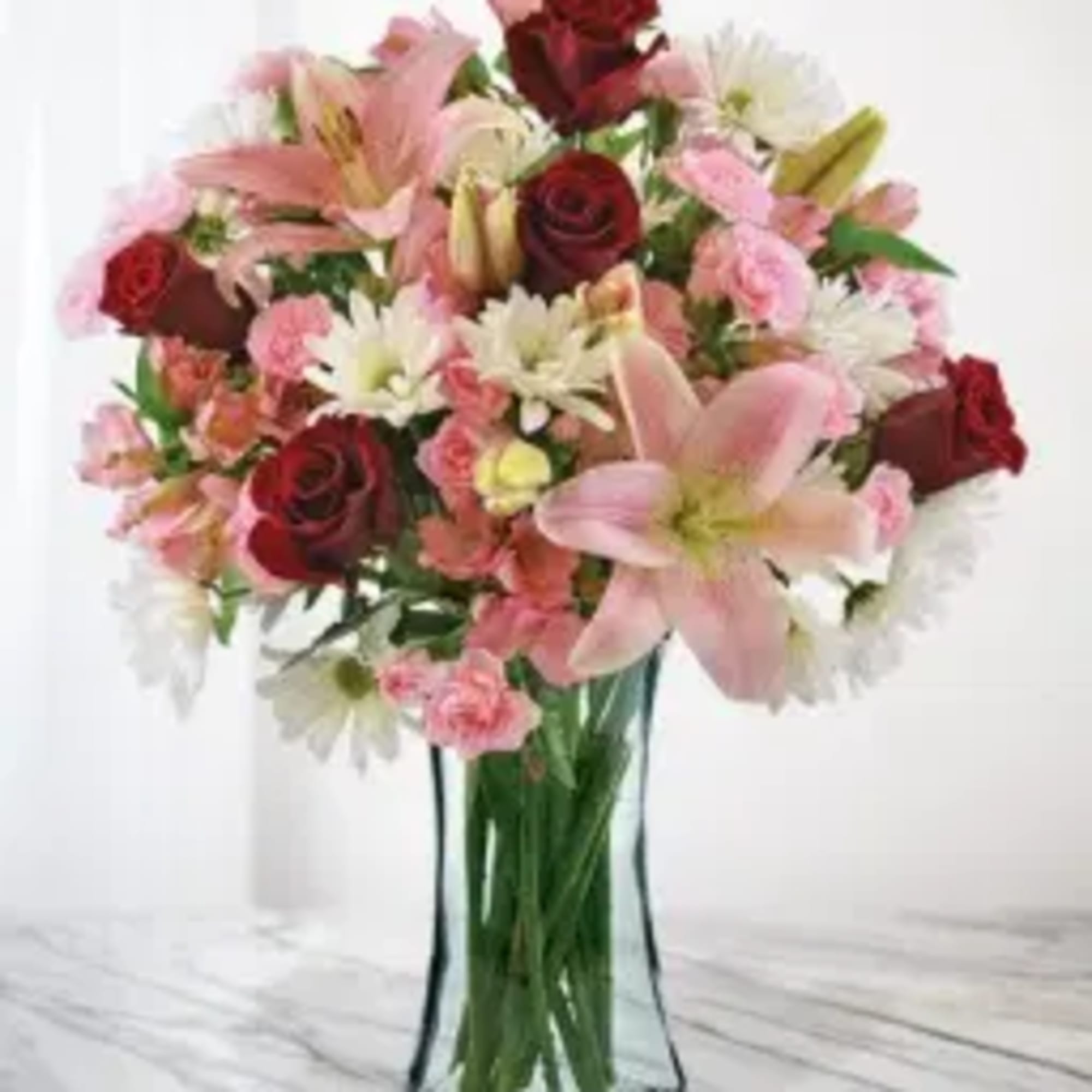 Bouquet of pink and red flowers in a clear glass vase