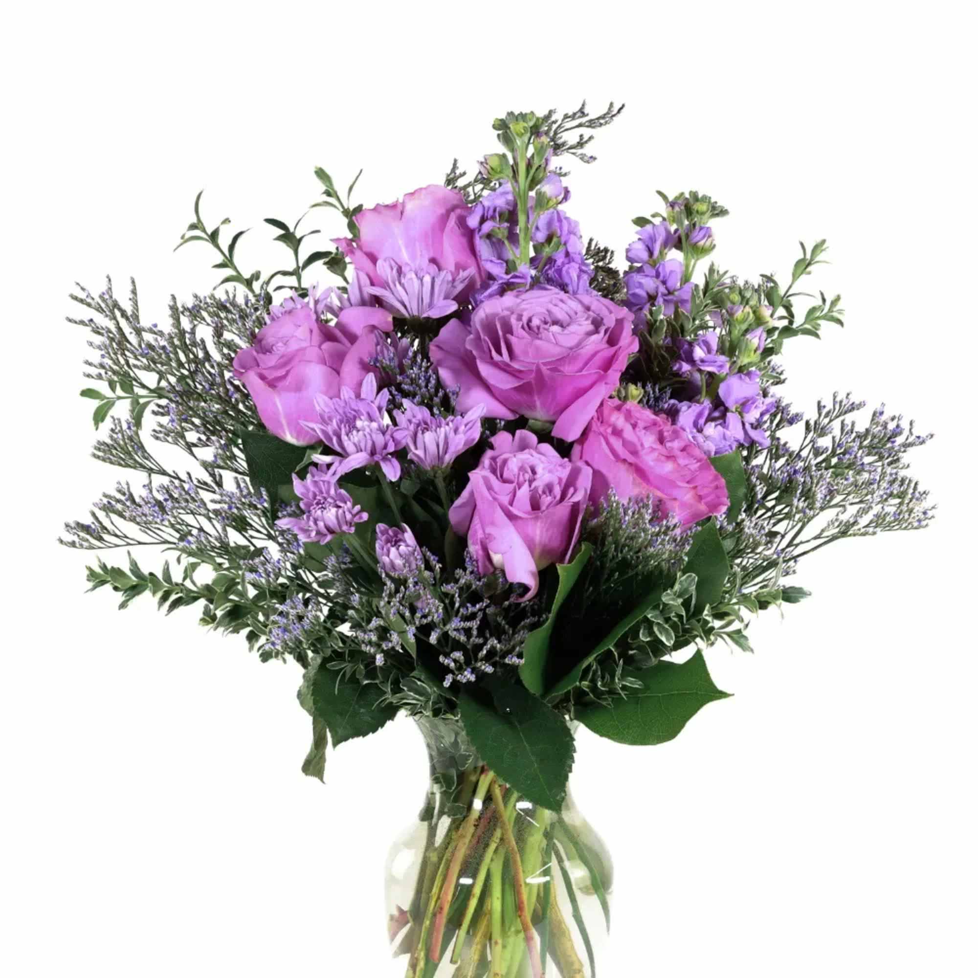 Purple roses and lavender flowers in a clear glass vase