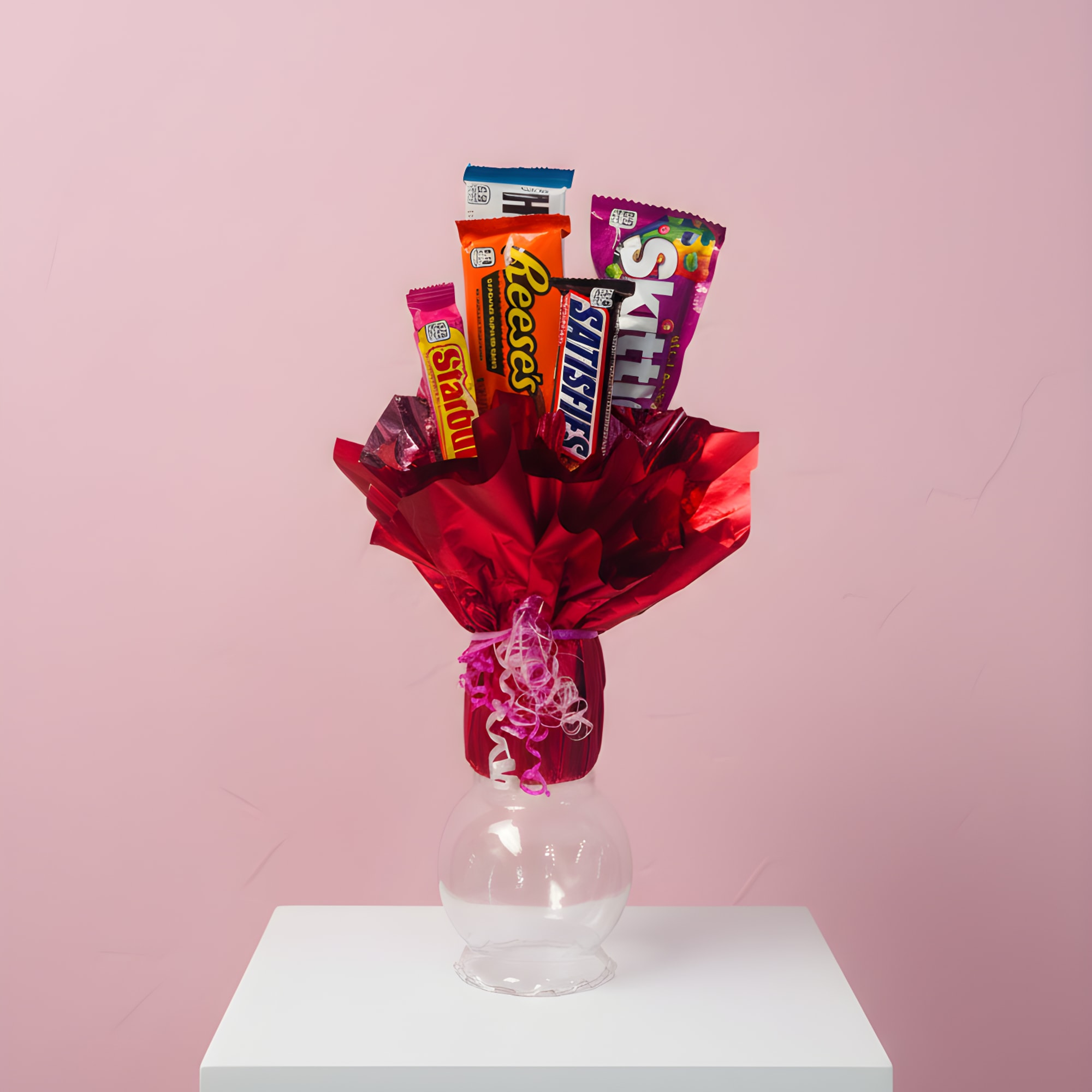 Candy bouquet in red wrapping with assorted chocolate bars in a clear vase