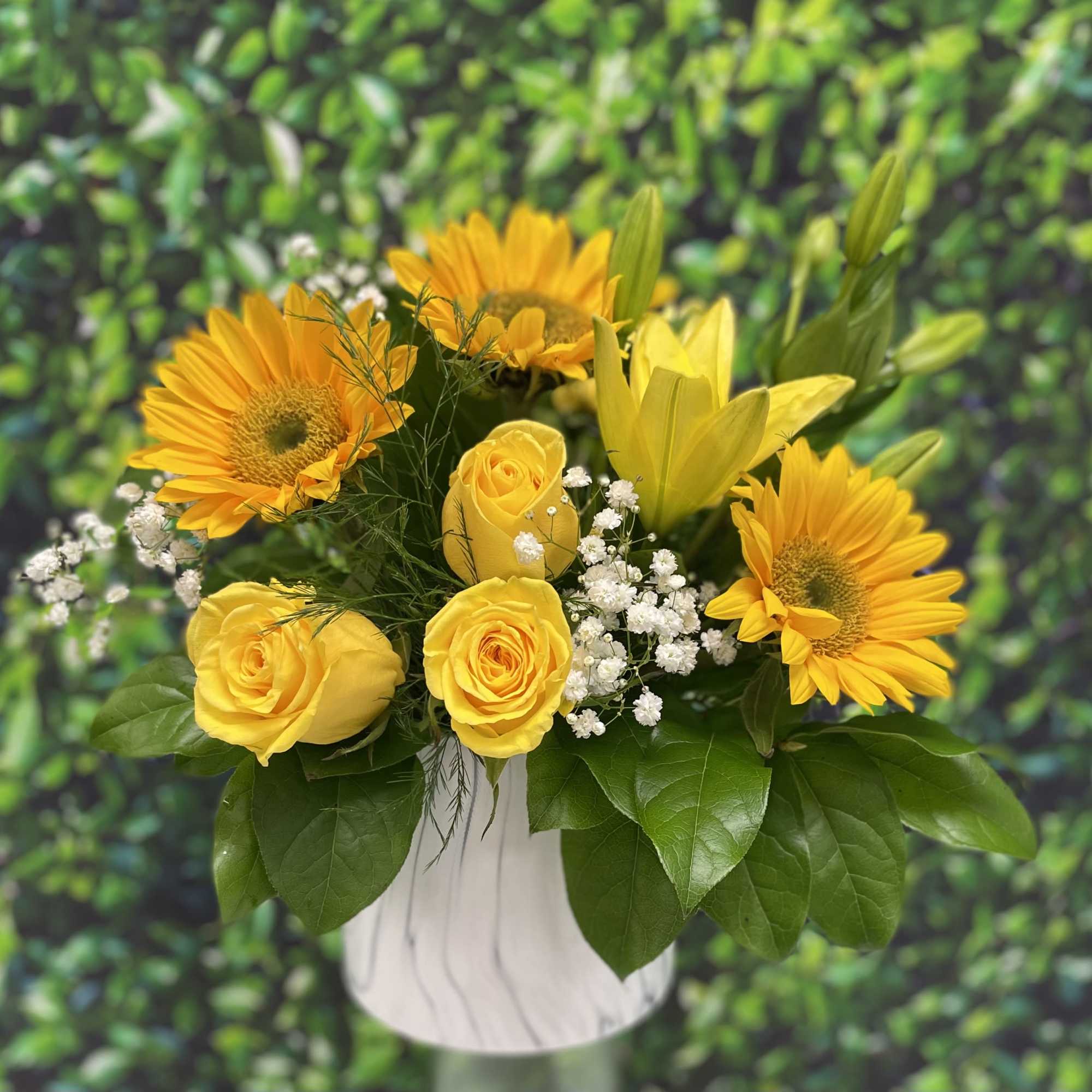 A stunning white marble keepsake vase with fresh greenery yellow roses sunflowers