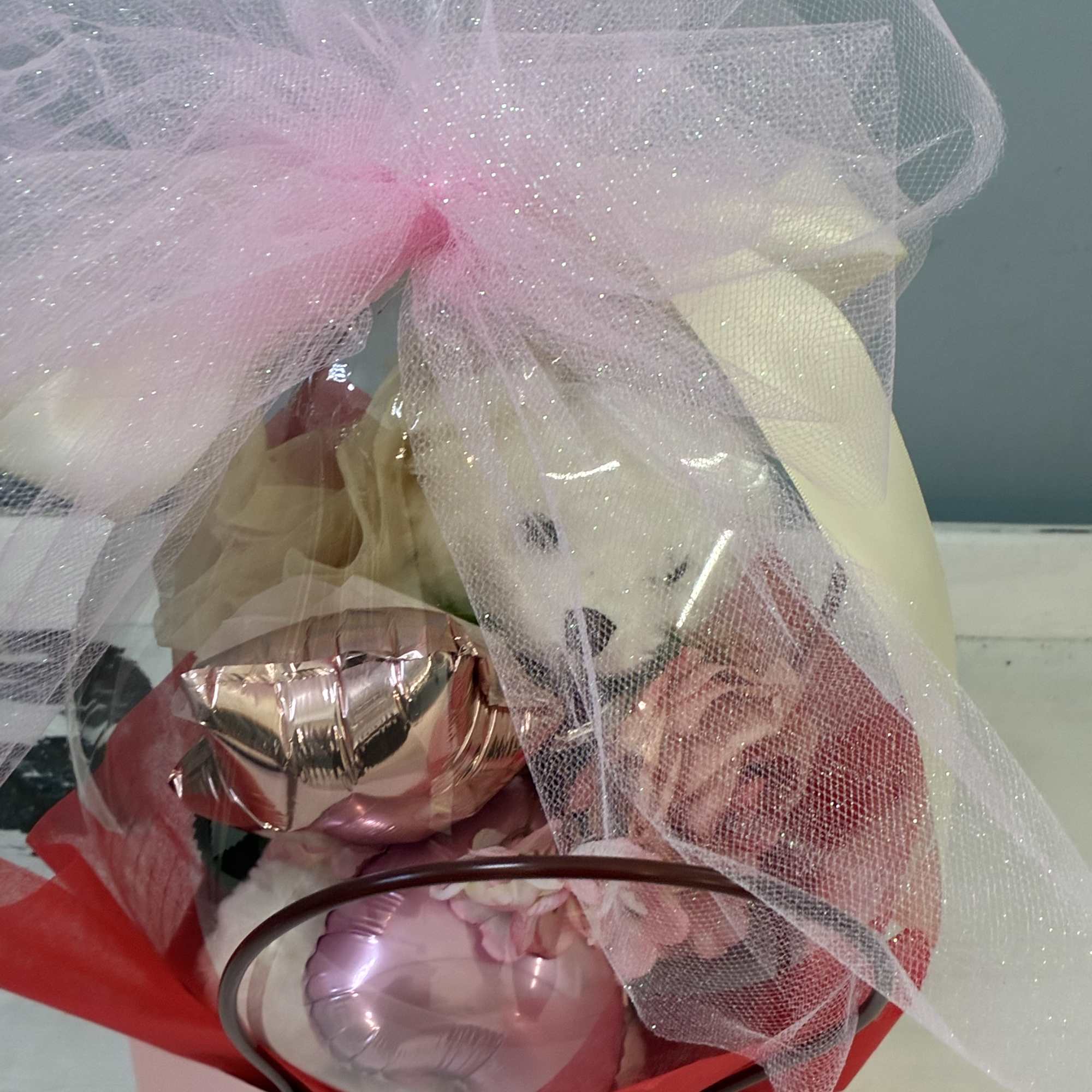 Gift basket with pink and white balloons wrapped in tulle