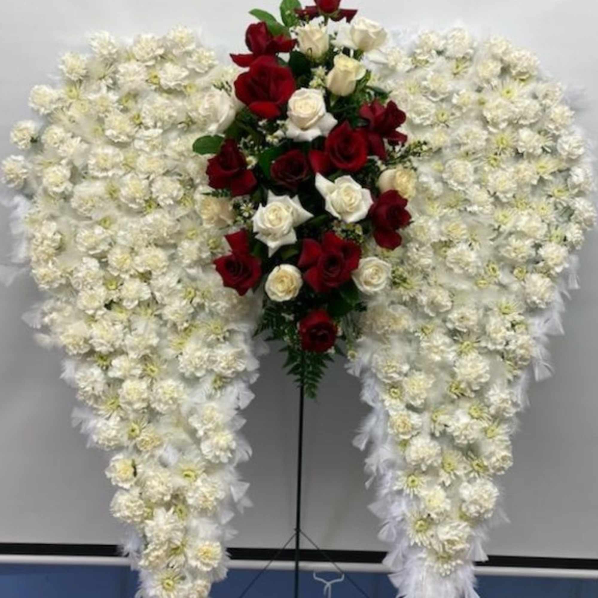 Standing floral spray with red and white roses surrounded by white flowers