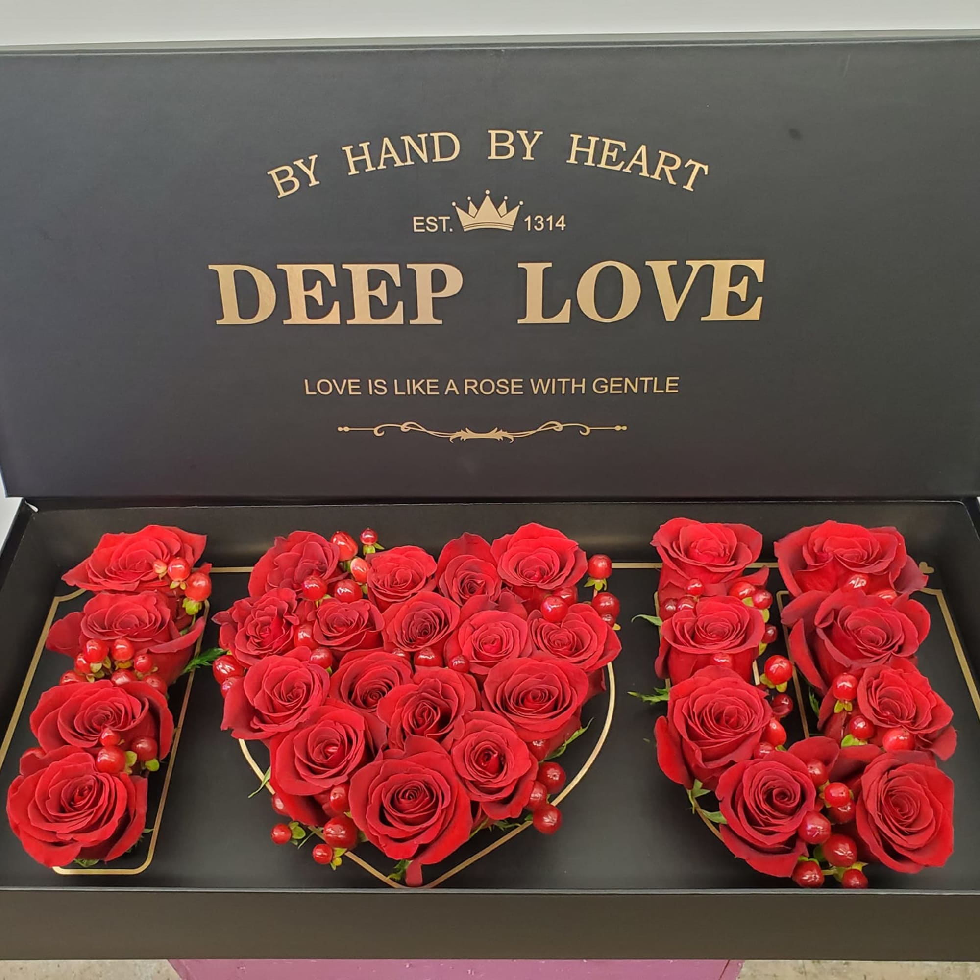 Red roses arranged in a gift box spelling "I LOVE U"