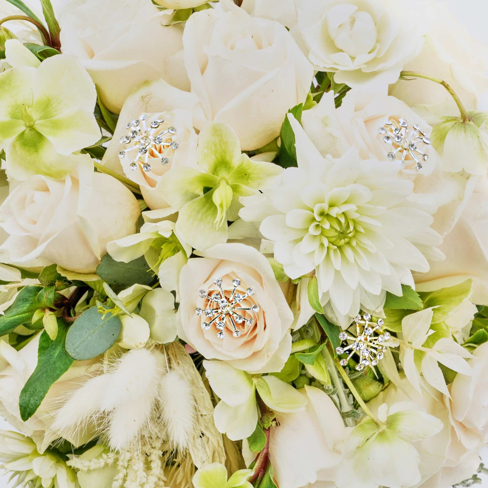 White floral bouquet with pale green accents and jeweled pins