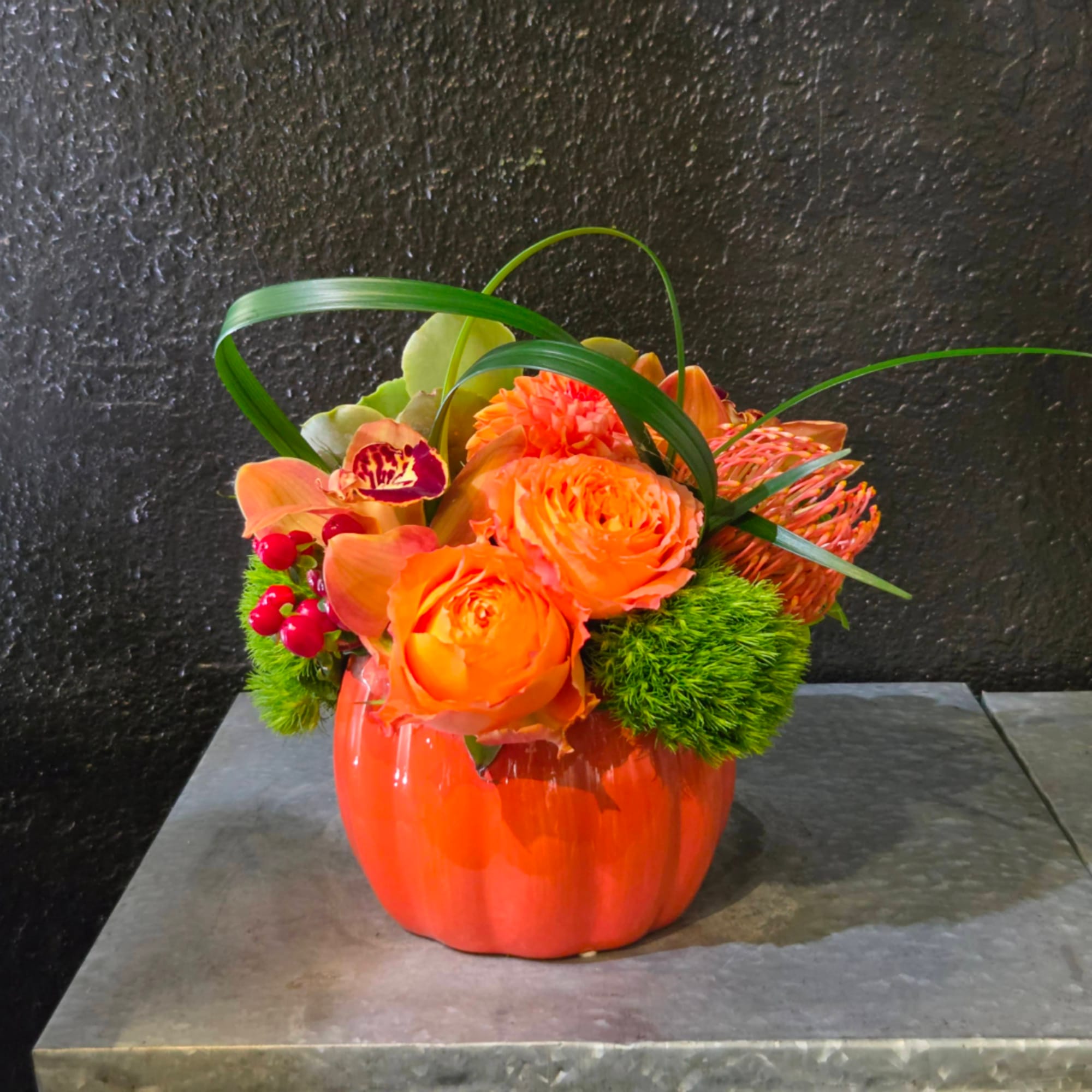 Orange floral arrangement in a pumpkin-shaped vase
