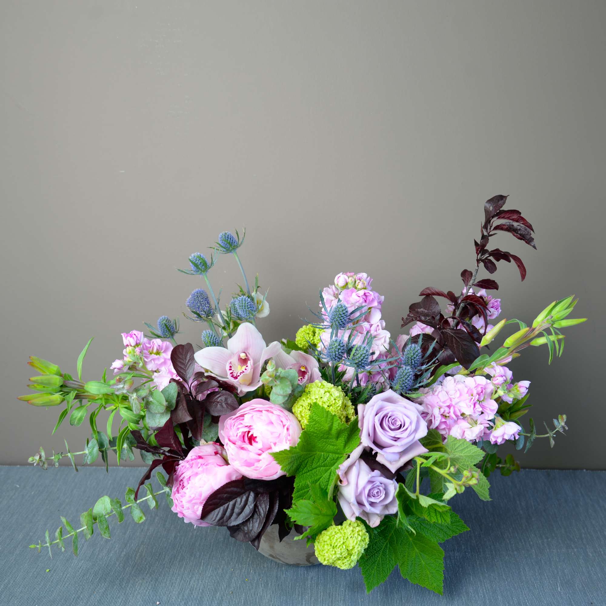 Mixed pink and lavender flowers in a low vase arrangement