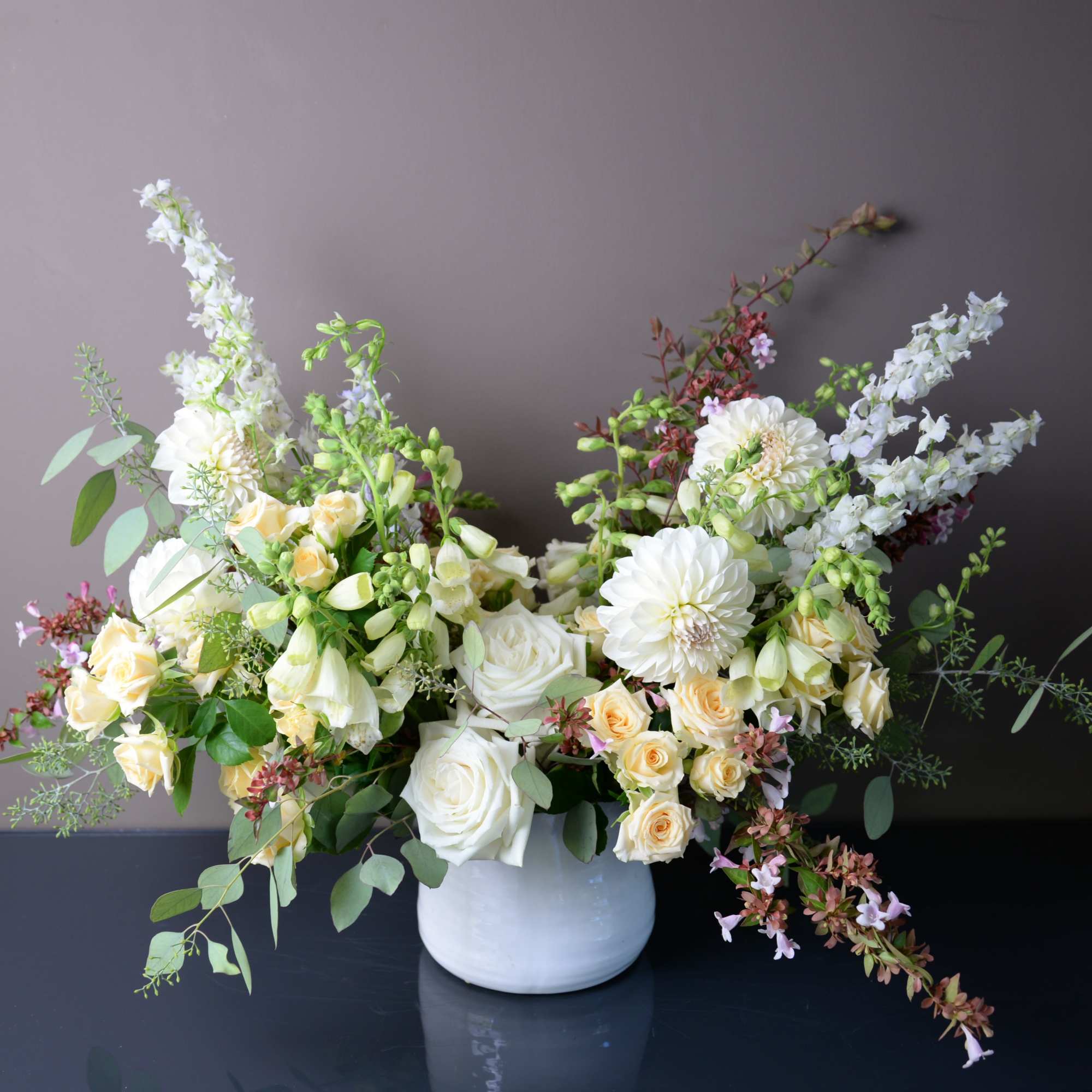 White and pale yellow floral arrangement in a white vase