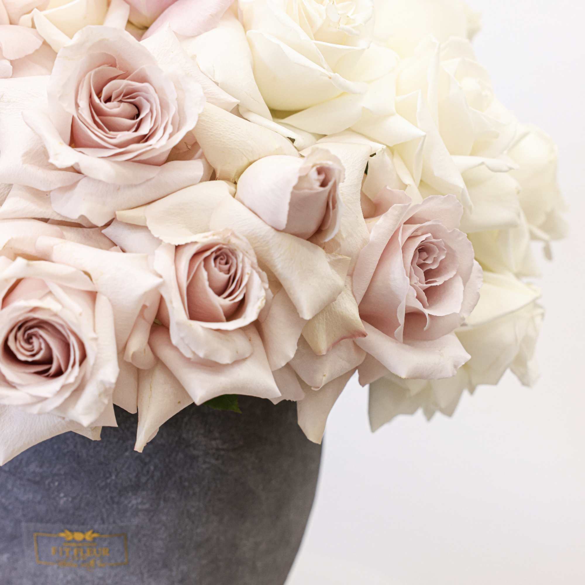 Blush and ivory roses arranged in a dark vase, photo 2 of 4
