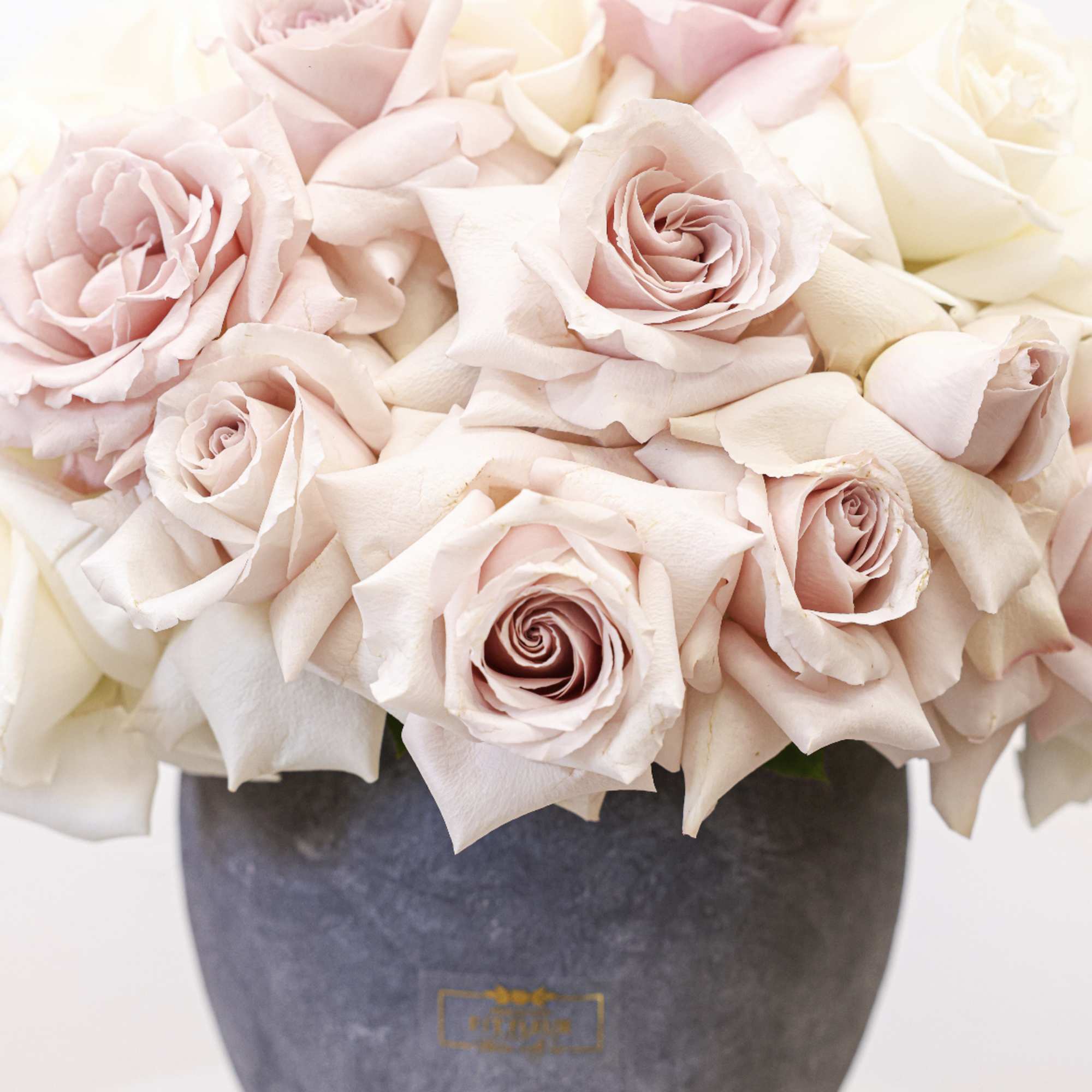 Blush and ivory roses arranged in a dark vase, photo 4 of 4