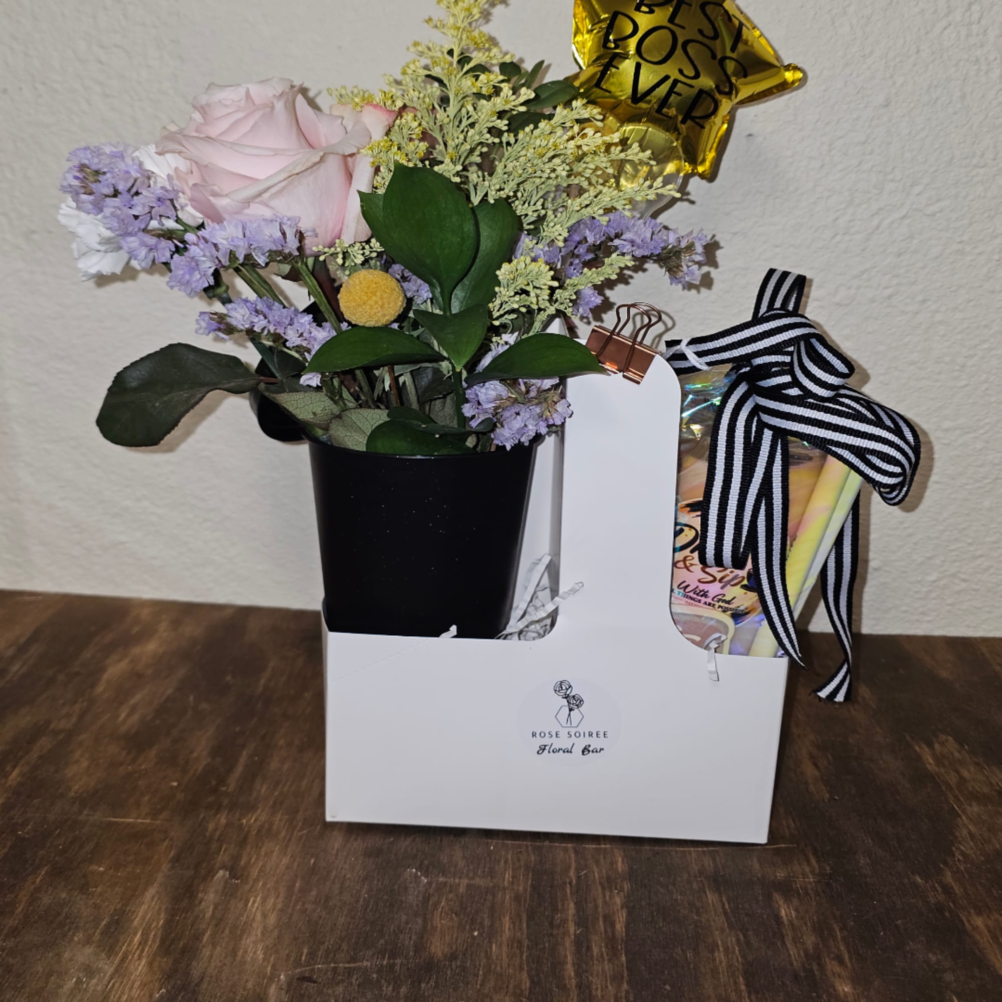 Pink rose arrangement in a black pot with a gift box and ribbon
