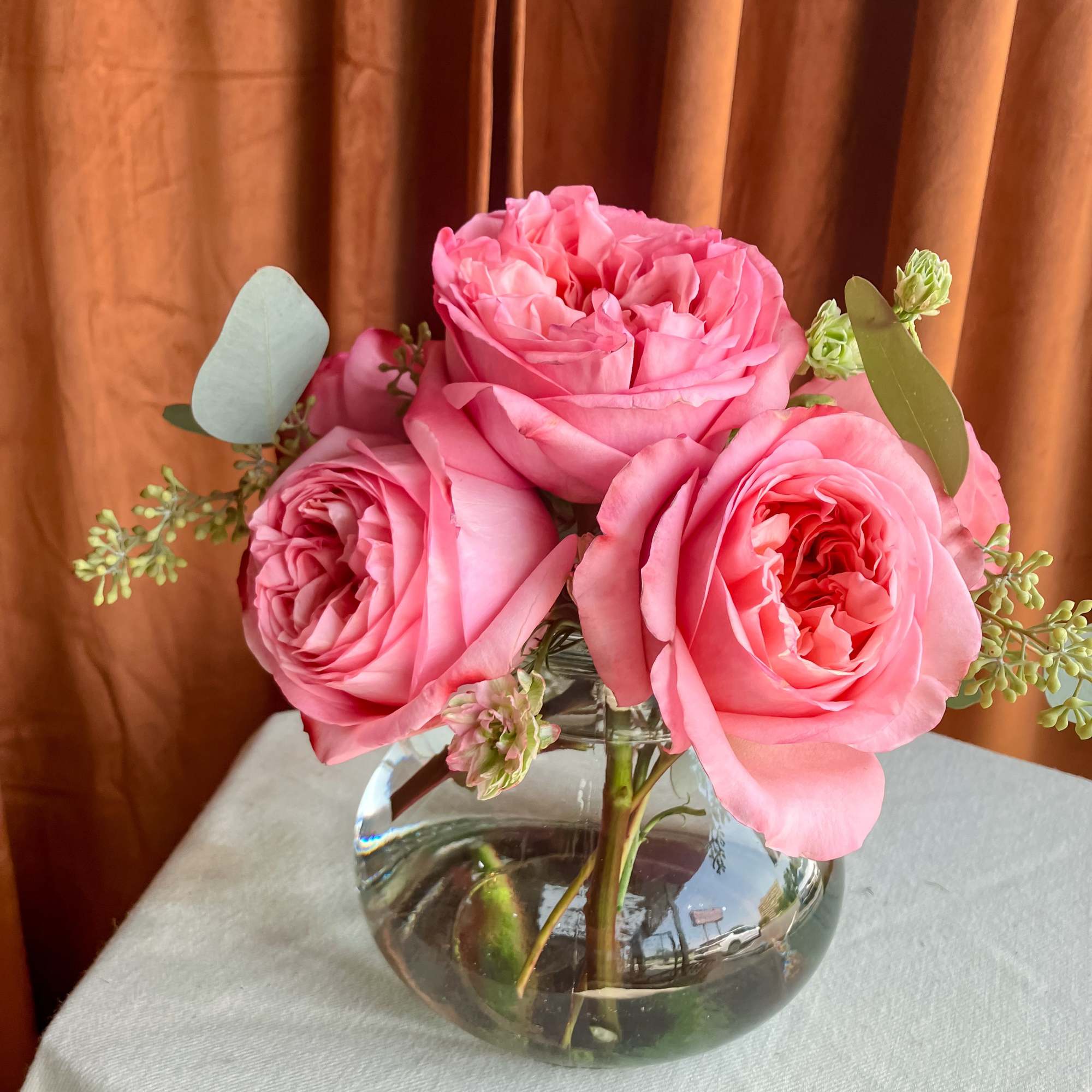 Pink roses arranged in a clear glass vase, photo 2 of 3
