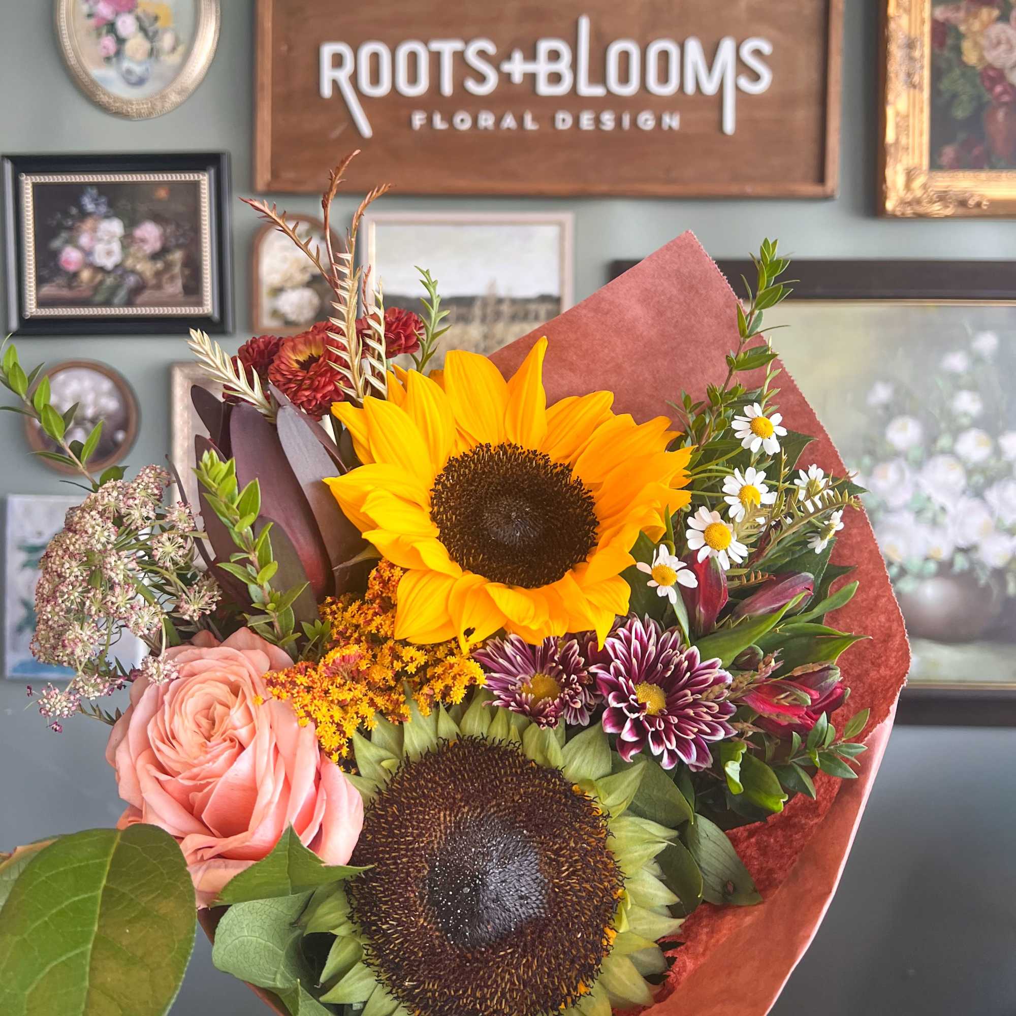 Bouquet with sunflowers, a pink rose, and small daisy-like blooms