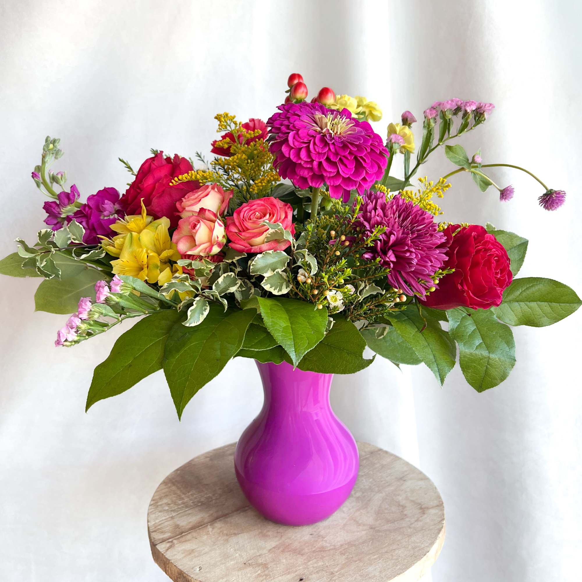 Mixed bouquet in a bright pink vase with roses and chrysanthemums