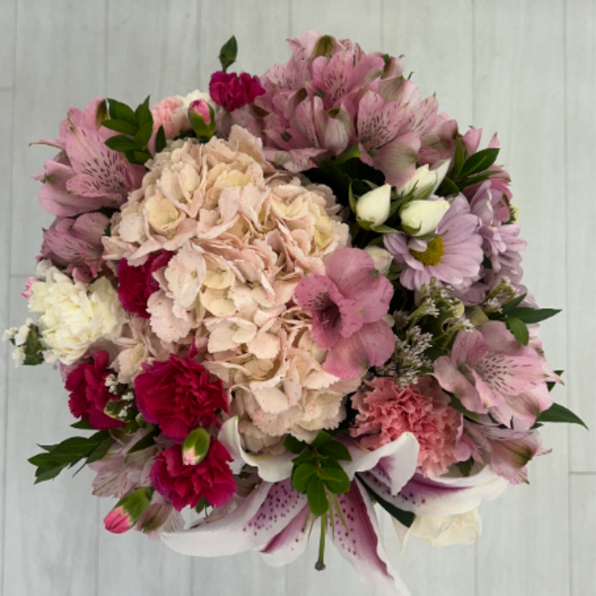 Welcome a precious little one with this soft and cheerful floral arrangement