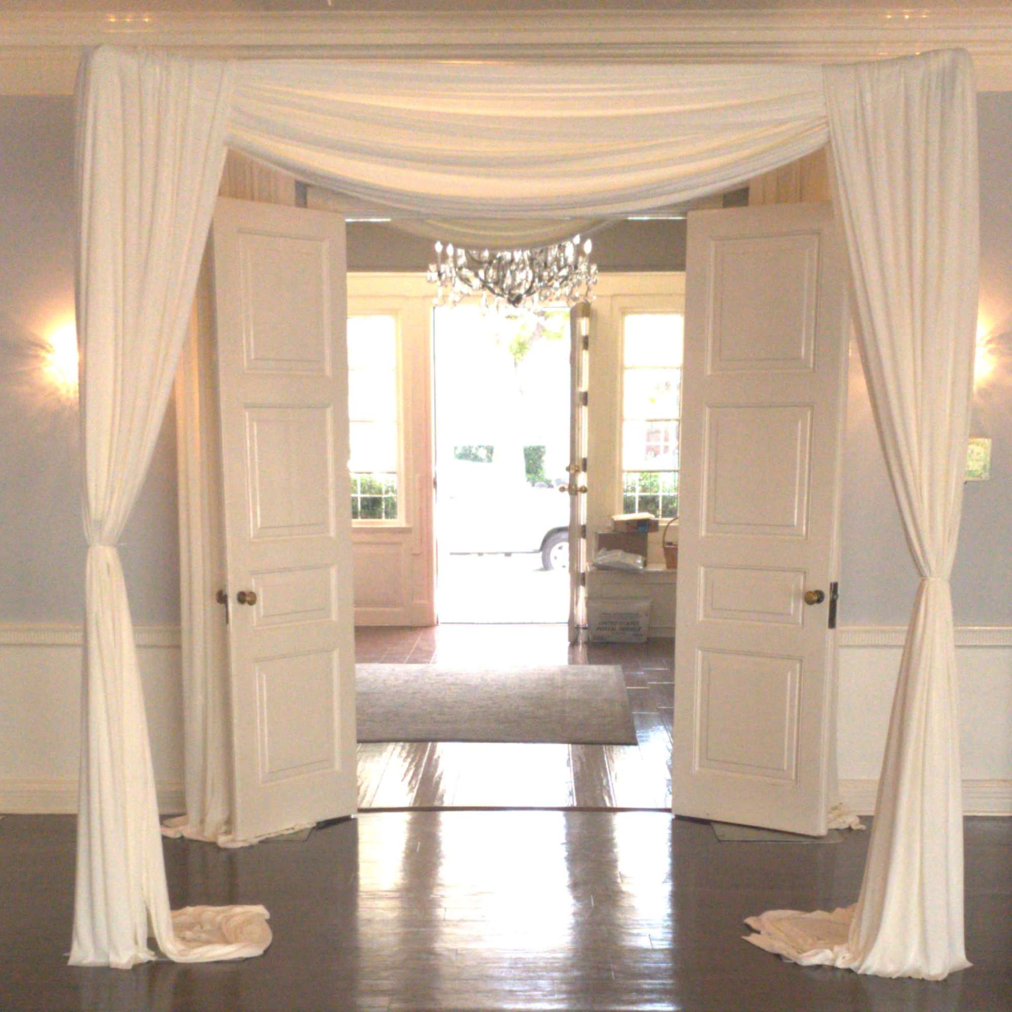 White draped fabric framing open double doors in an interior room
