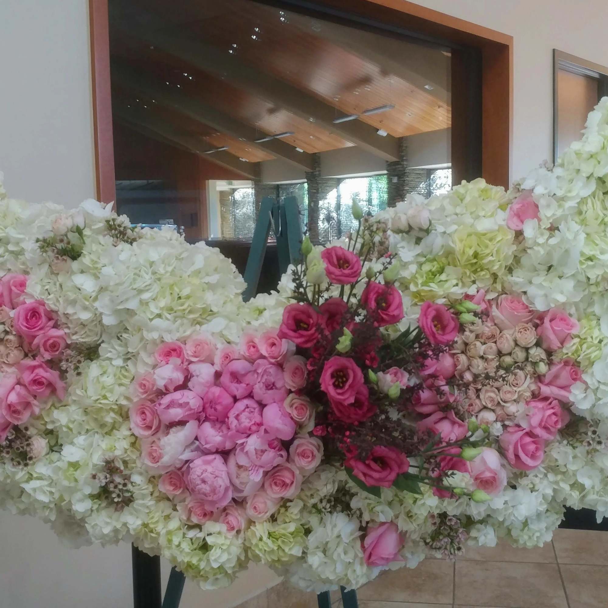 Large floral arrangement of white and pink flowers on a stand