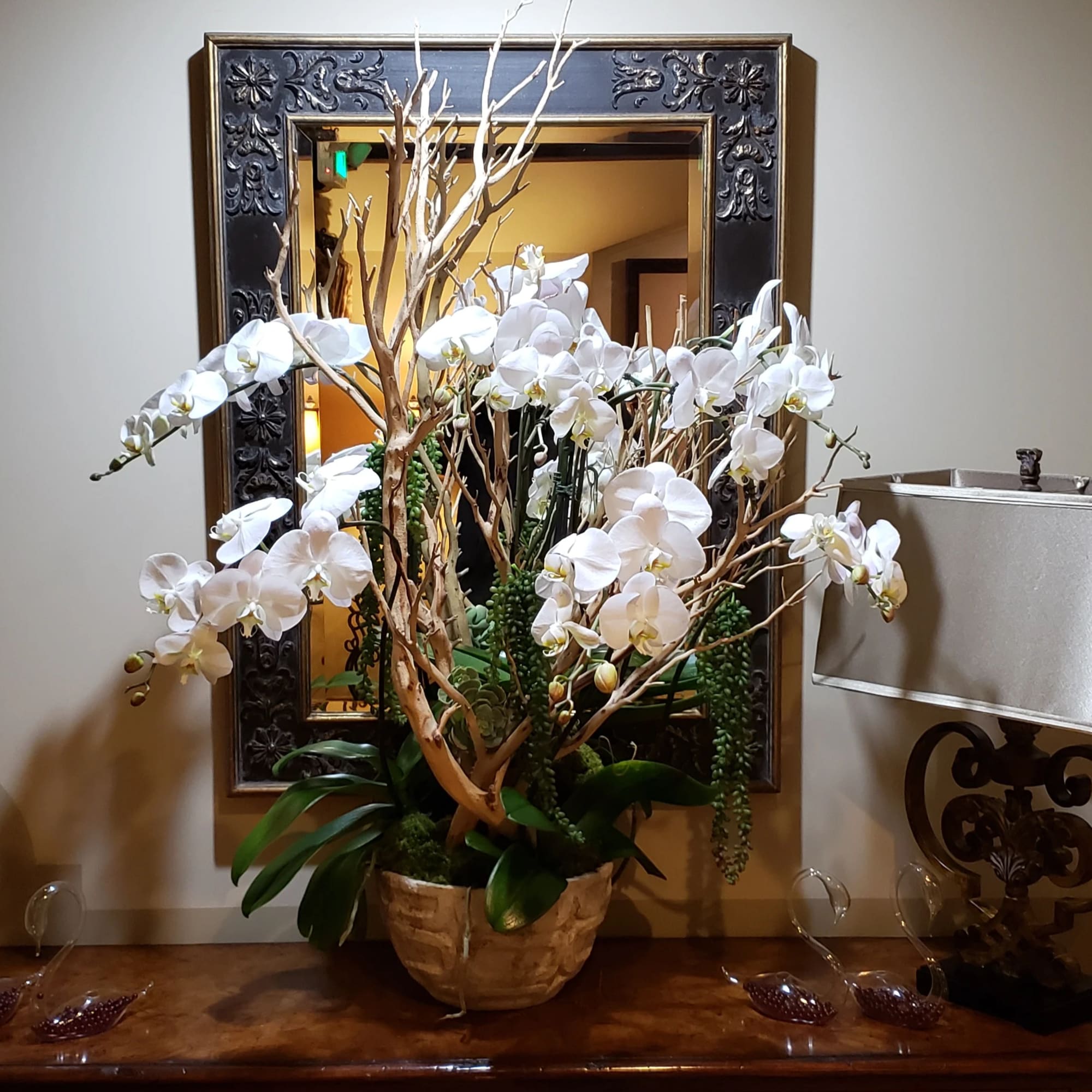 White orchid arrangement in a decorative pot on a table