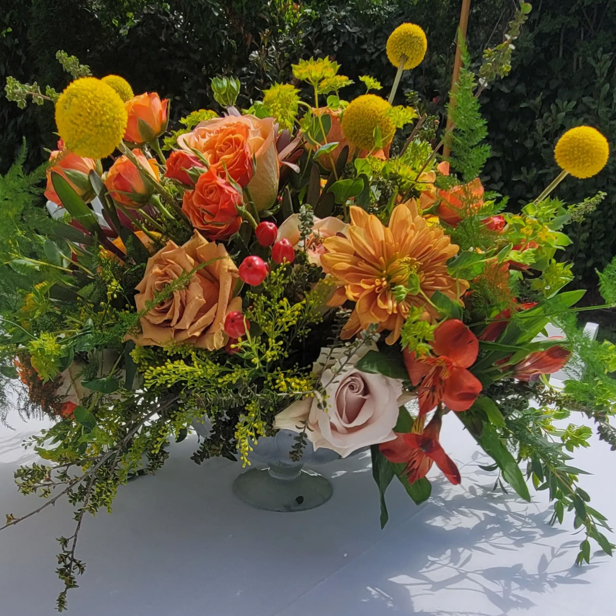 Orange and peach floral arrangement in a glass vase