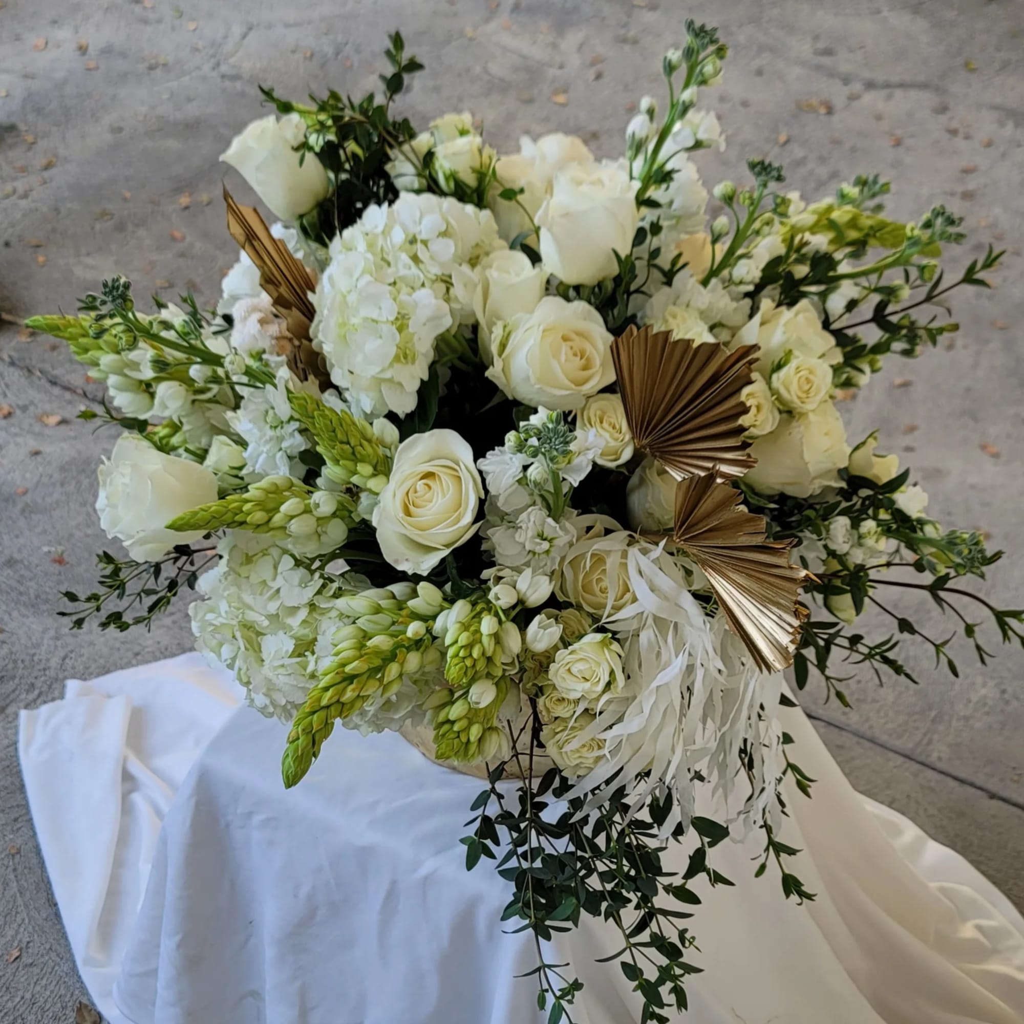 White rose and hydrangea bouquet with green accents and gold fan decorations