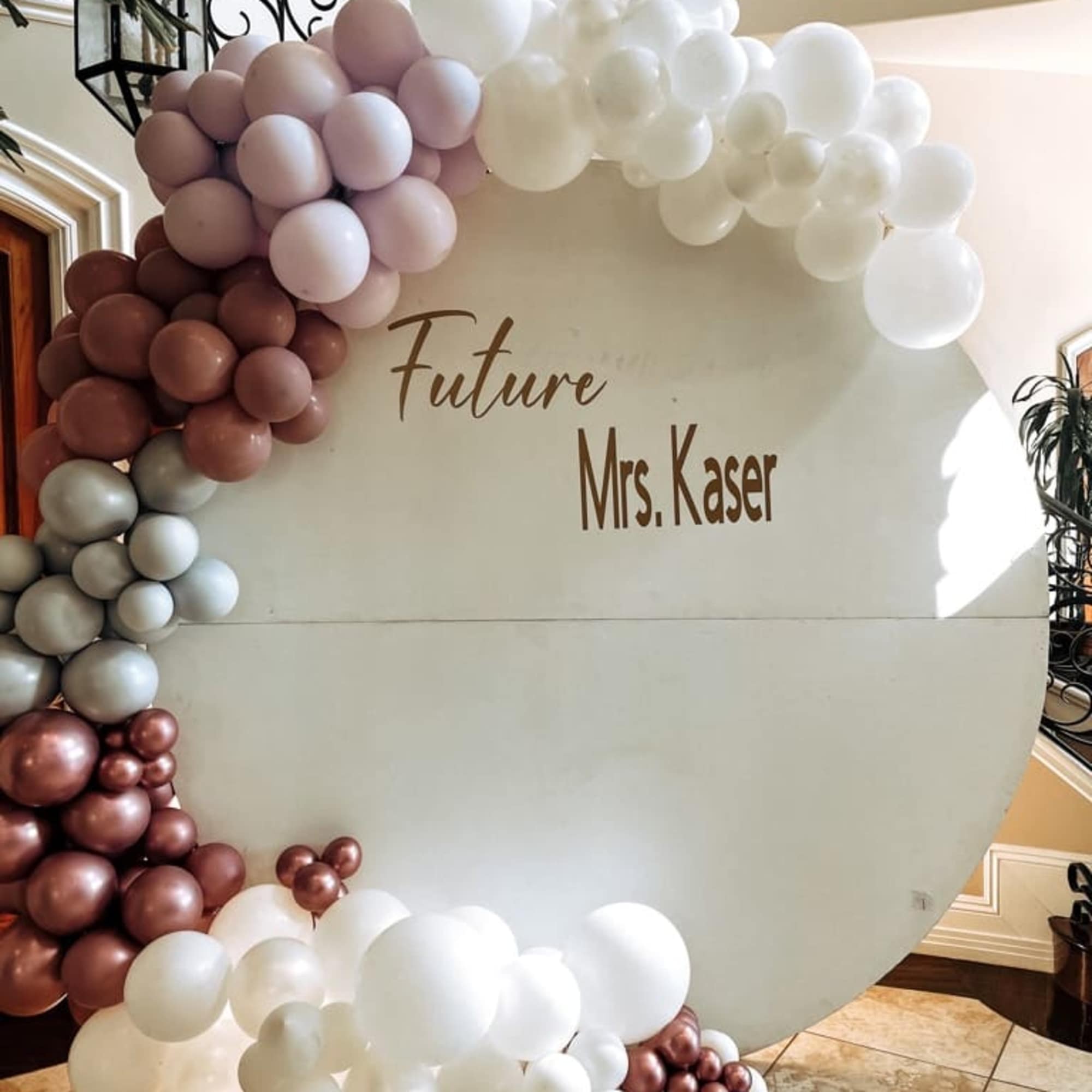 Balloon arch in white, blush, and rose gold around a sign reading Future Mrs. Kaser