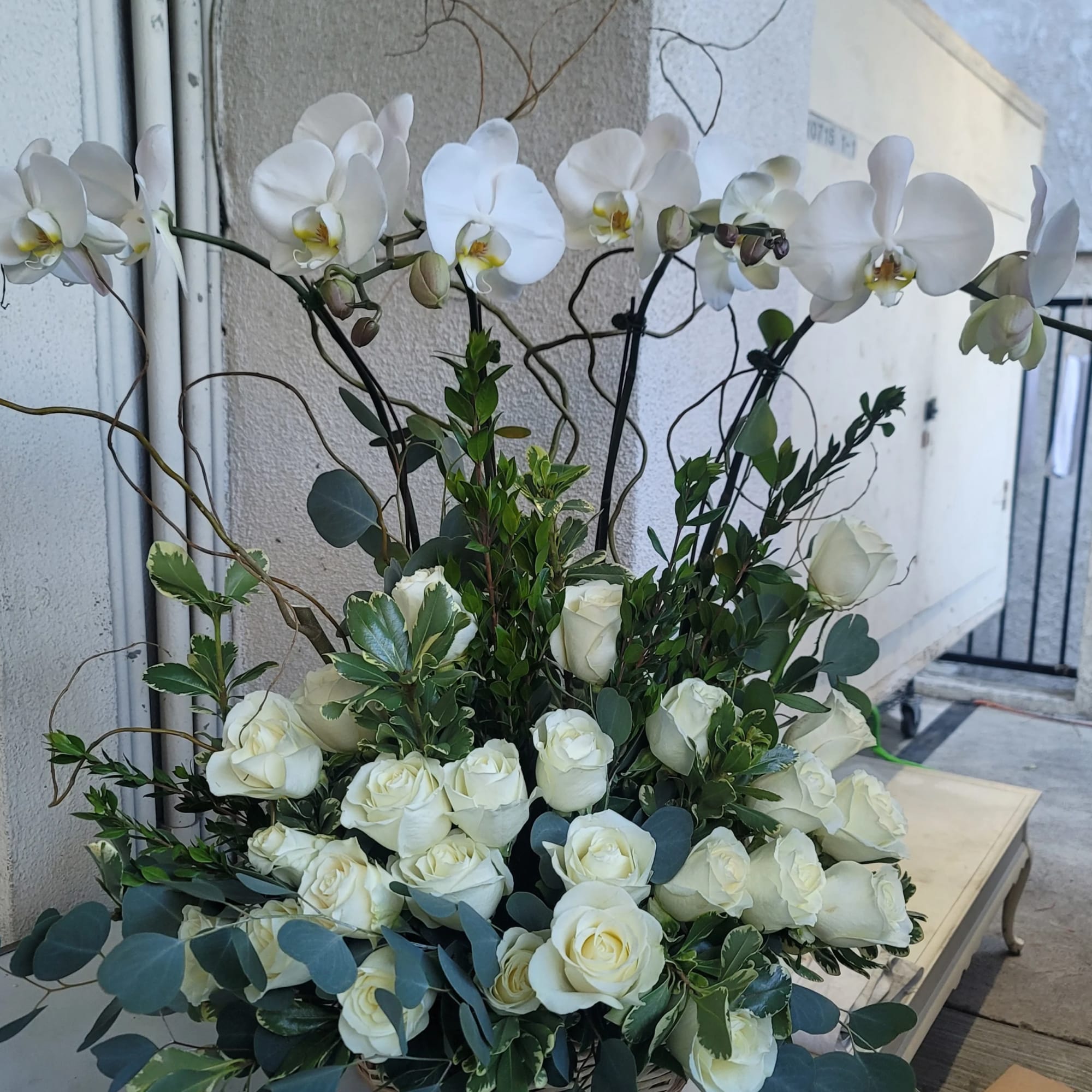 White roses and orchids arranged in a large floral display