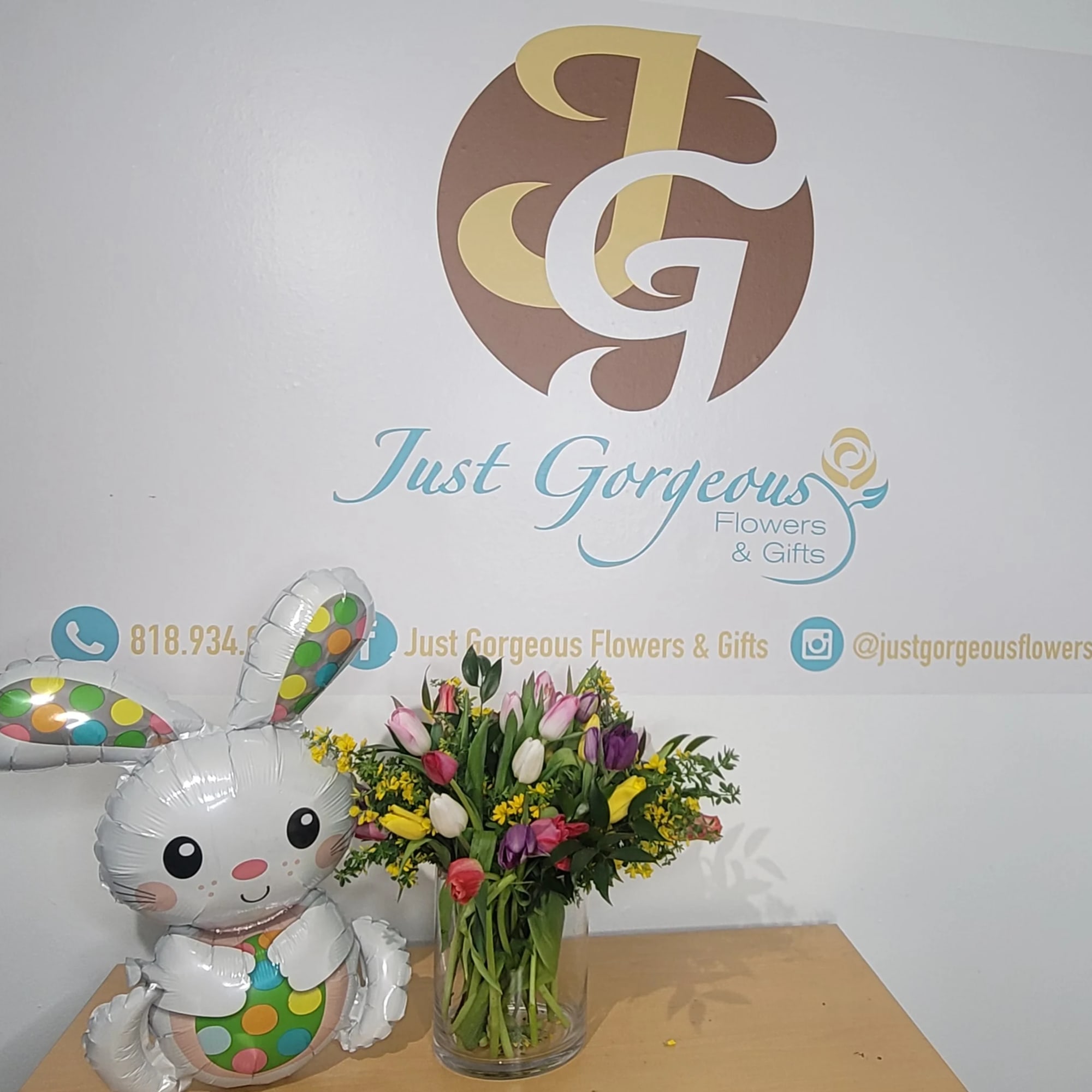 Tulip bouquet in a glass vase beside a bunny balloon