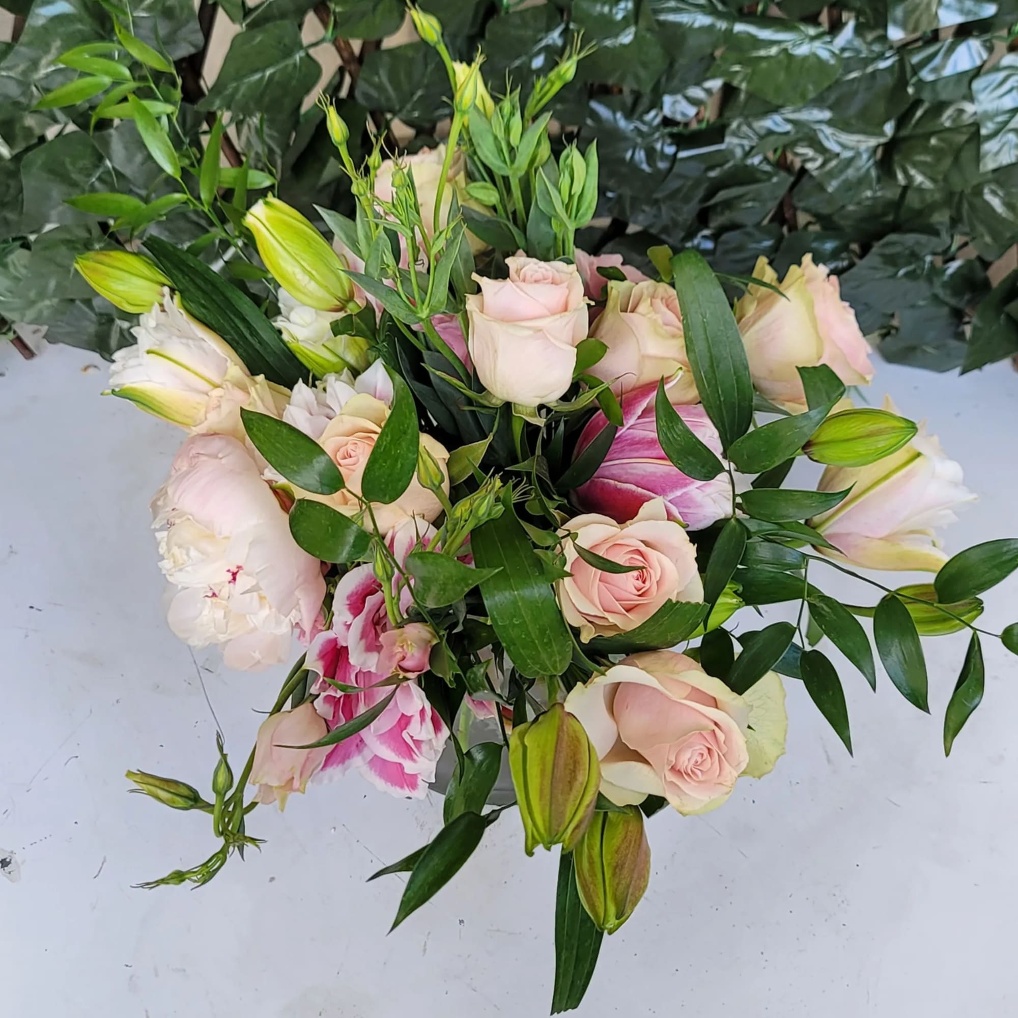 Bouquet of pale pink roses and lilies with green foliage