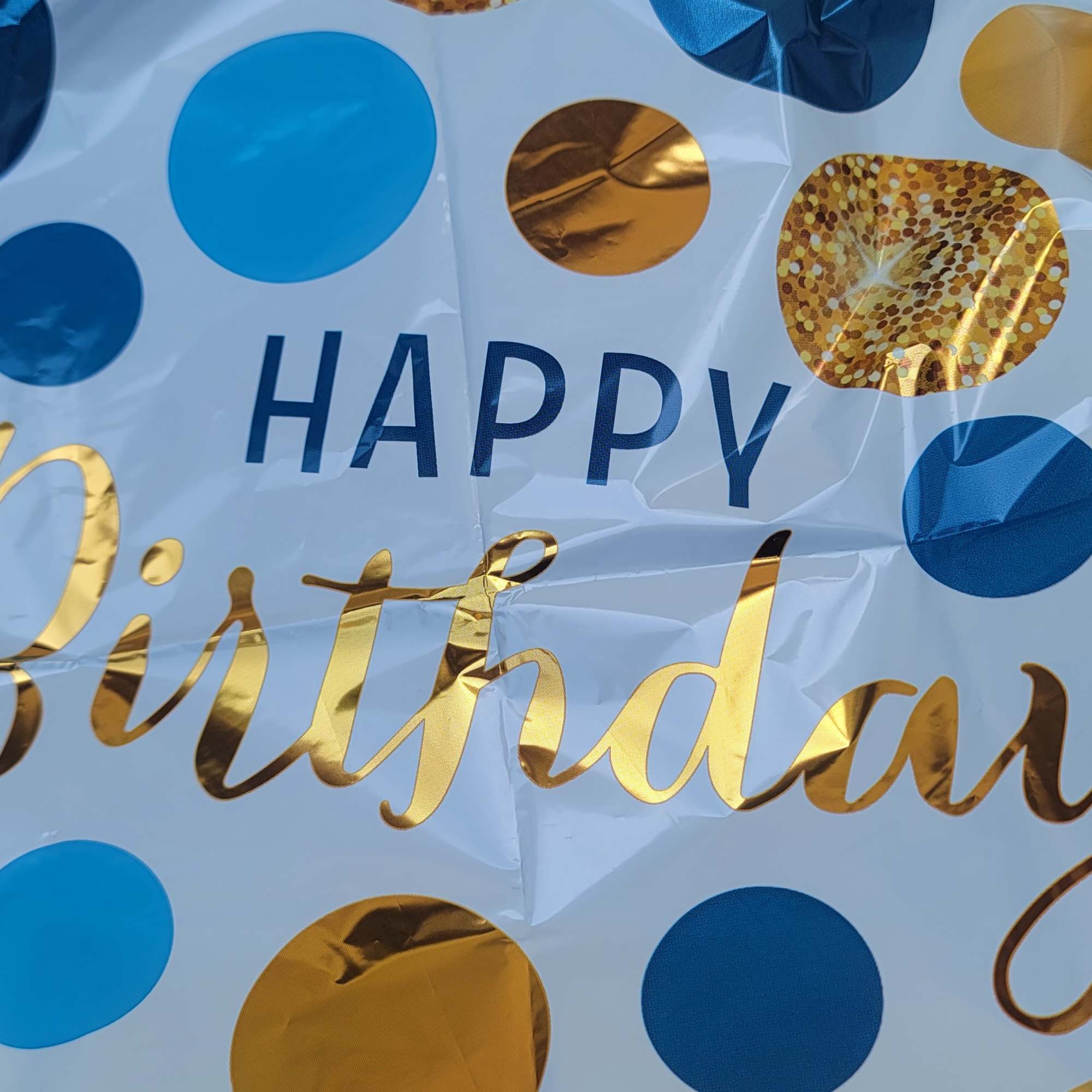 Large "Happy Birthday" balloon with blue and gold polka dots