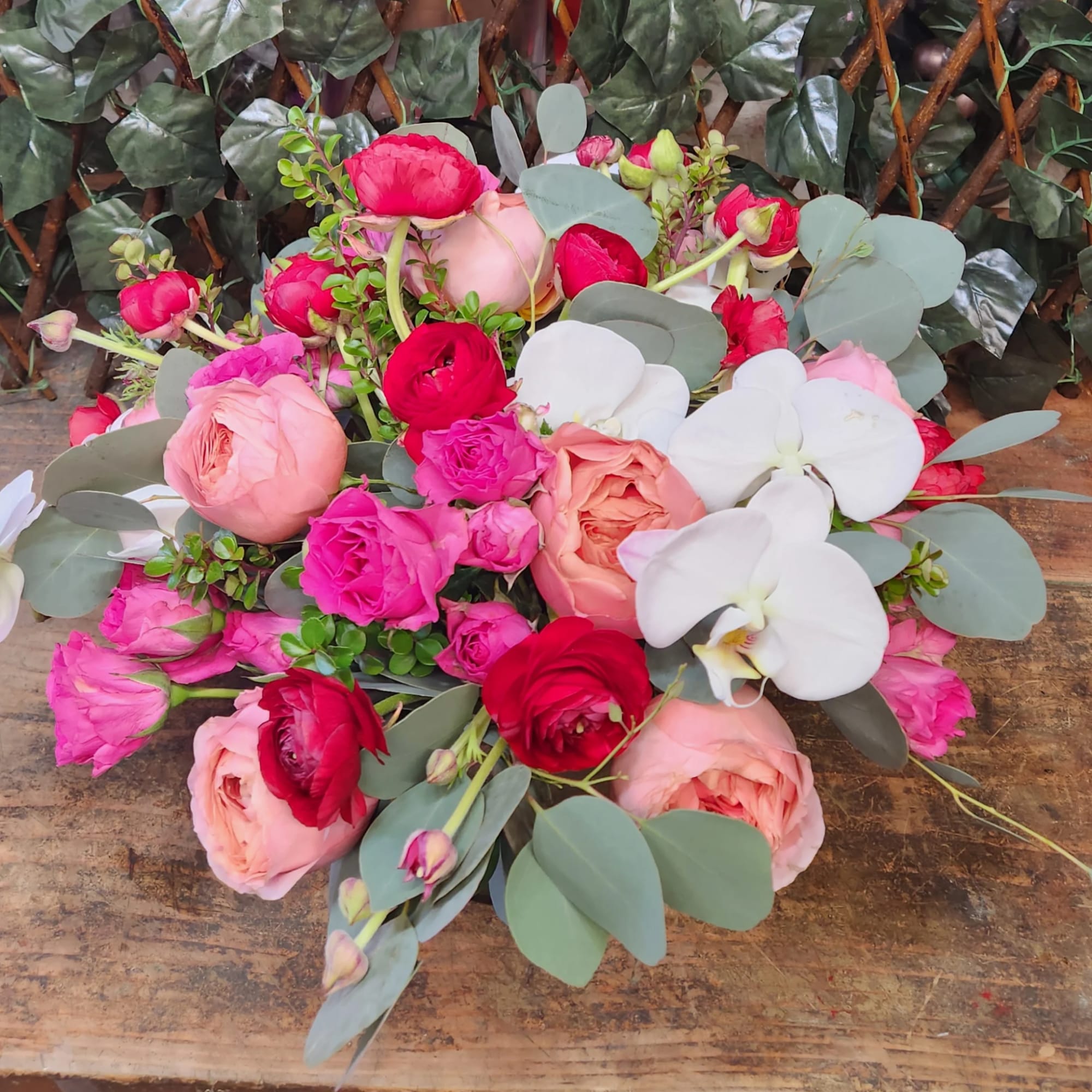 Mixed bouquet of pink and red roses with white orchids