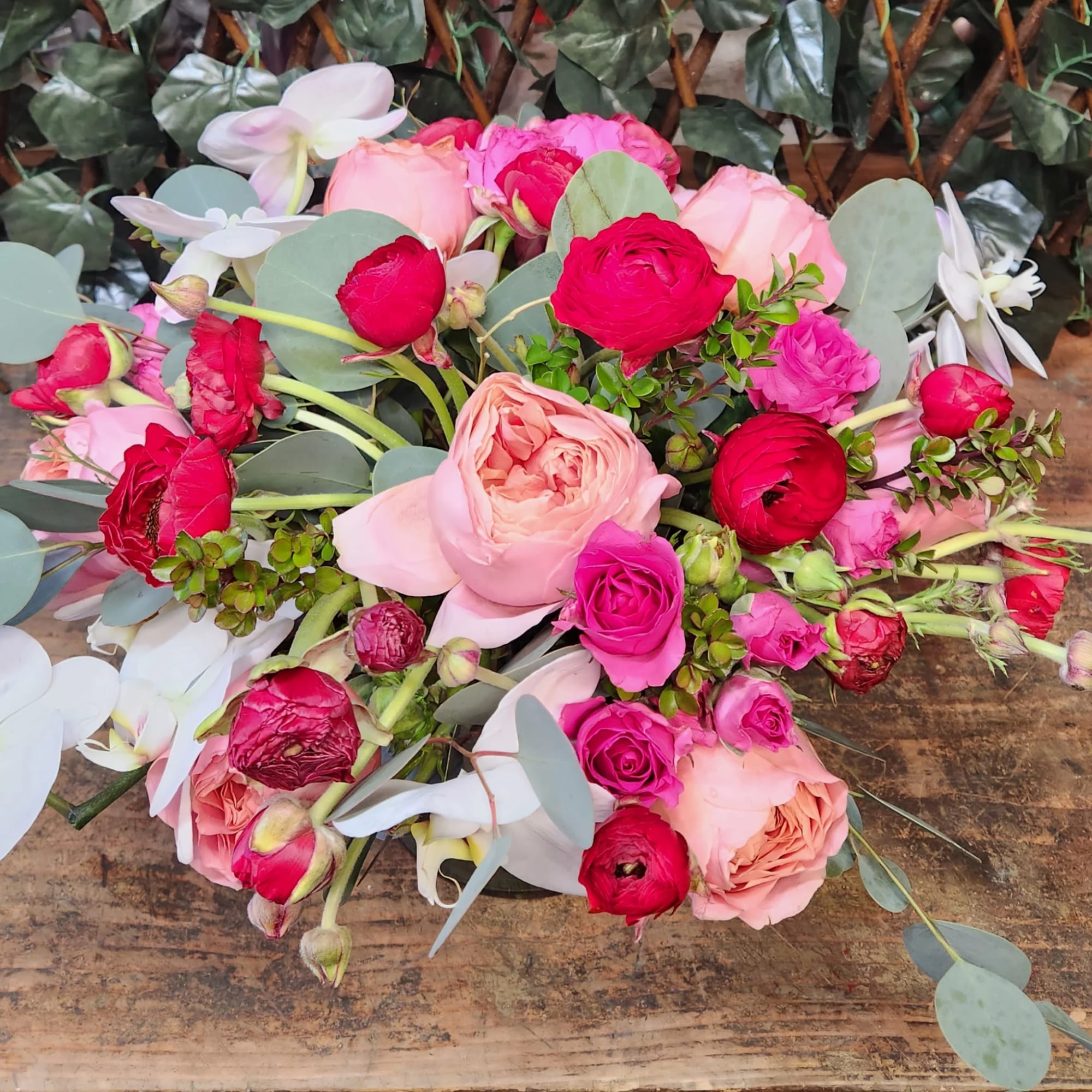 Bouquet of pink and red roses with white orchids and eucalyptus