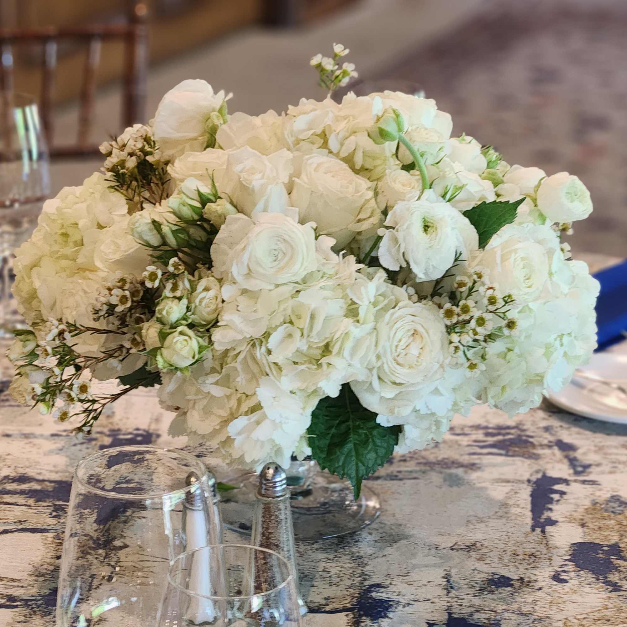 White rose and hydrangea centerpiece on a banquet table